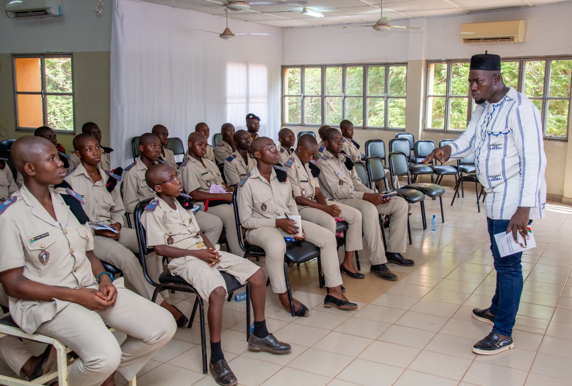 Social And Developmental Psychology — A teacher engages with uniformed students in a classroom discussion, highlighting education and learning.