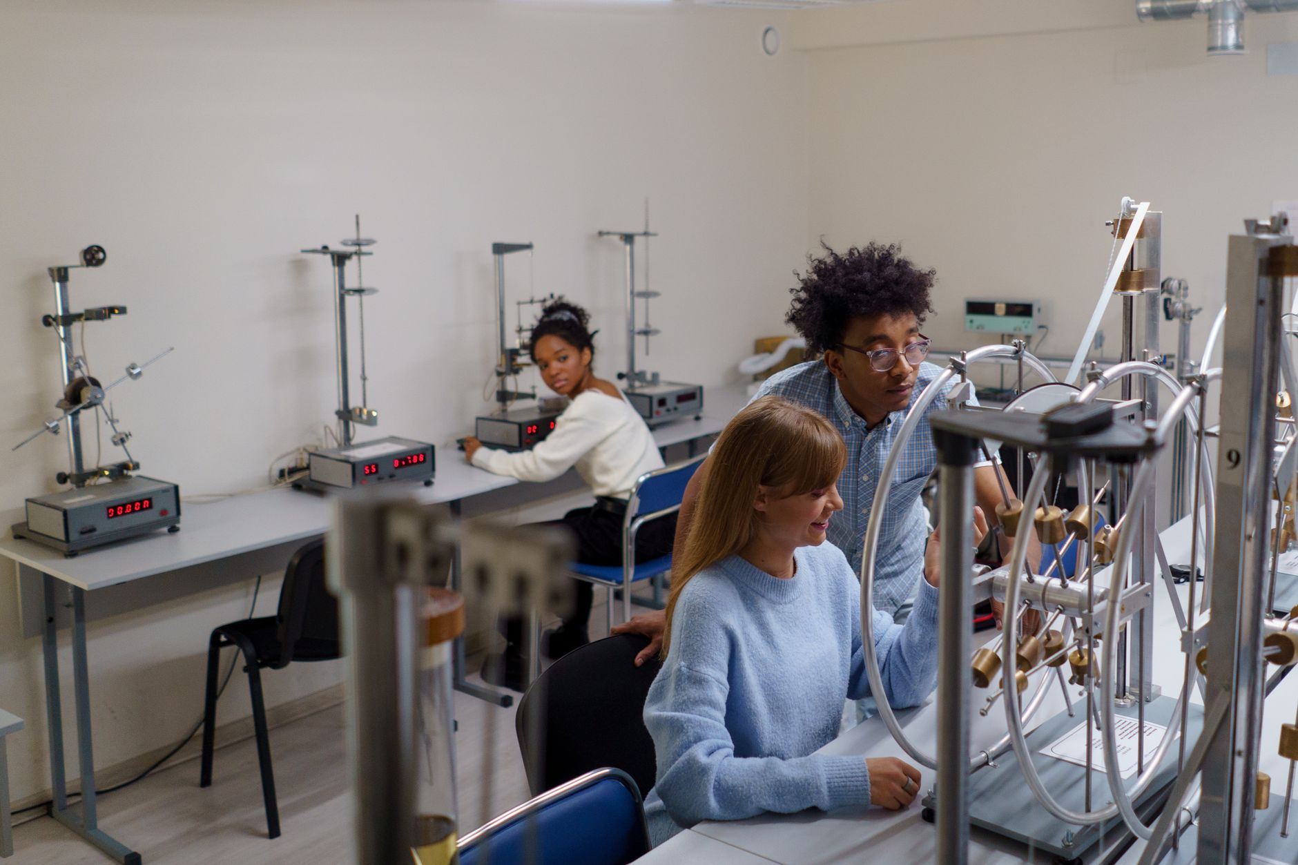Sustainability and Ethics in Health and Safety Practice — University students conducting physics experiments in a science laboratory, collaborating and learning in an interactive setting.