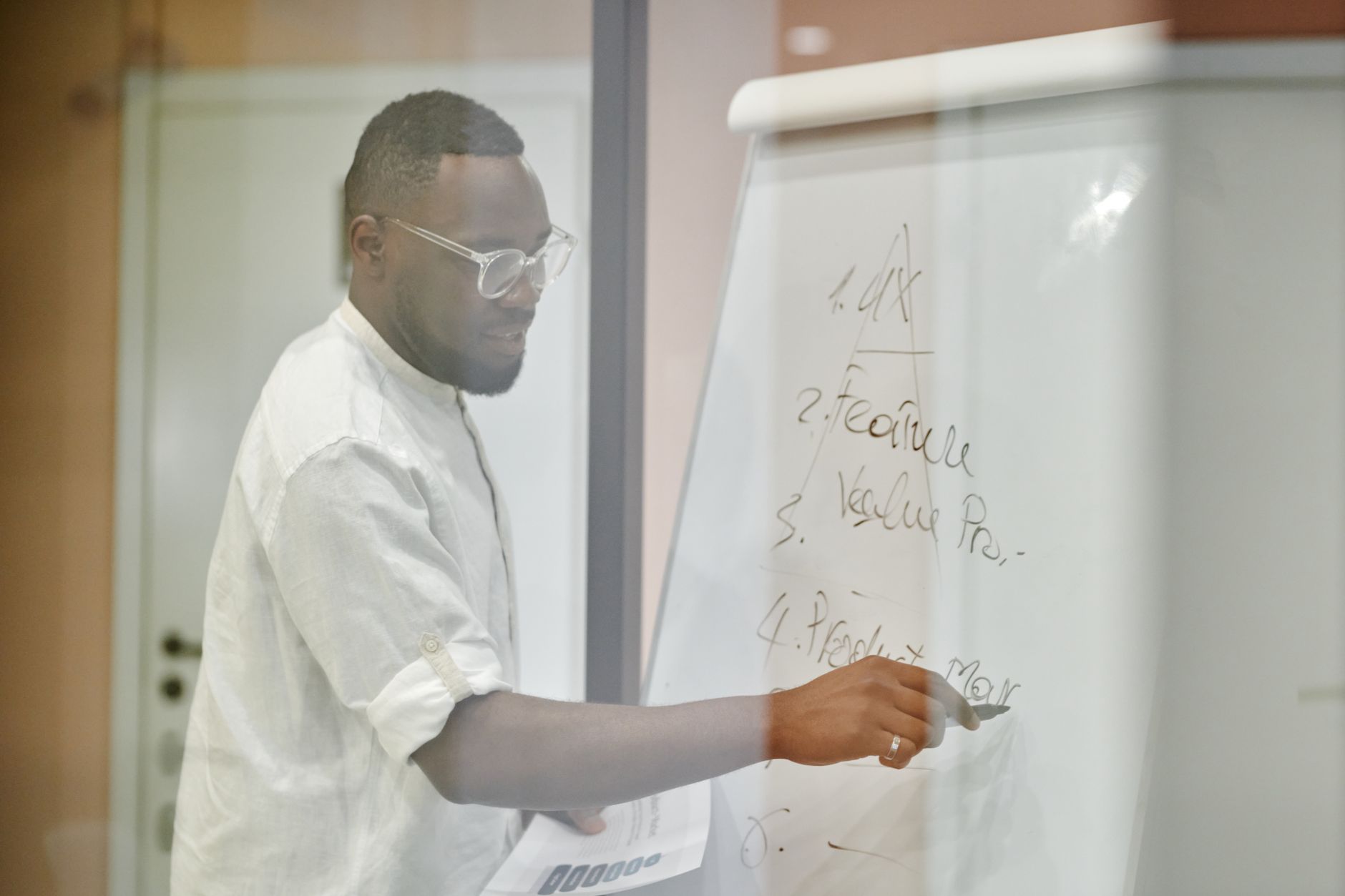 Process Safety Management Systems — Professional man presenting business strategy on a whiteboard in a modern office setting.