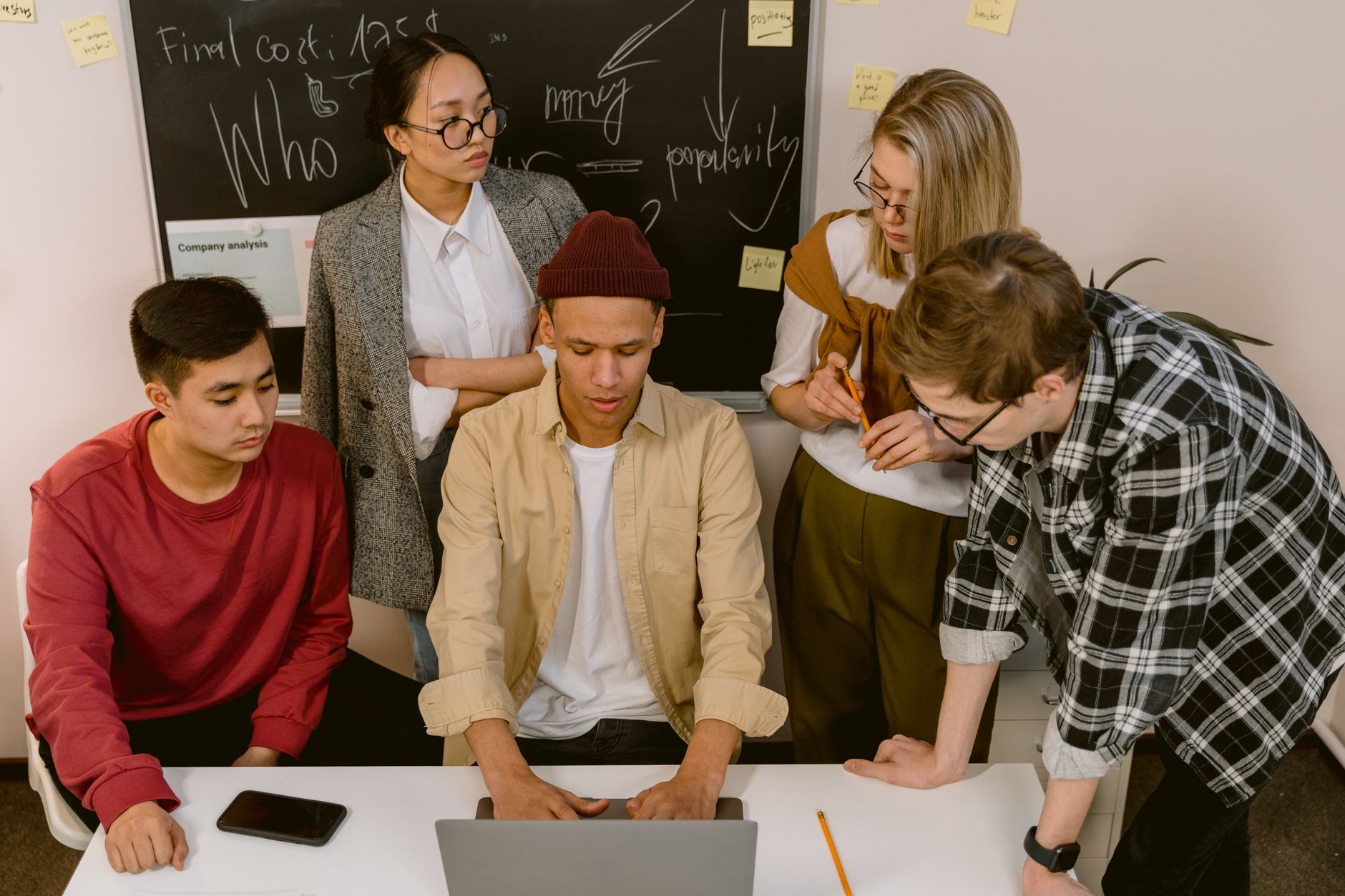 Development as a Strategic Manager — A group of young professionals brainstorming and collaborating in an office setting, focused on teamwork and innovation.