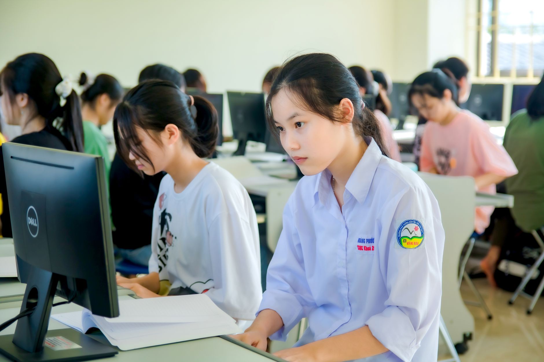 Cultural Tourism Management — A group of students focused on computer screens in a modern classroom setting.