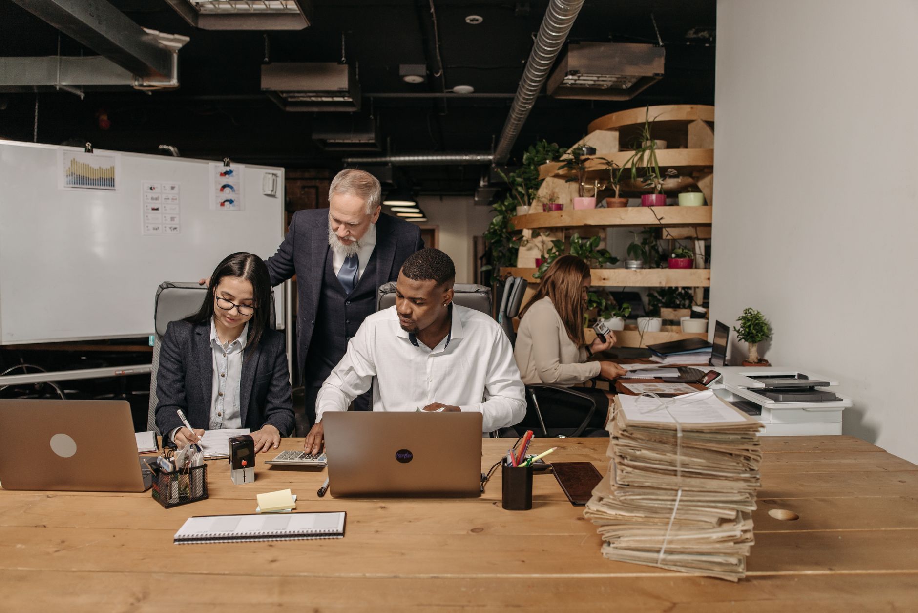 Operations Management in Tourism and Resort Operations — Team of professionals working collaboratively in a modern office environment with documents and laptops.