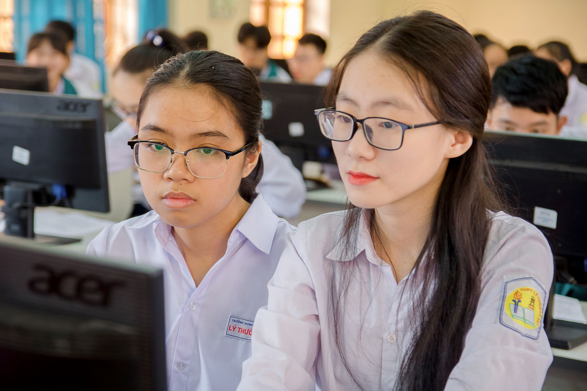 Management of Visitor Attractions — Two female students in a classroom focusing on computer work, showcasing education and technology.