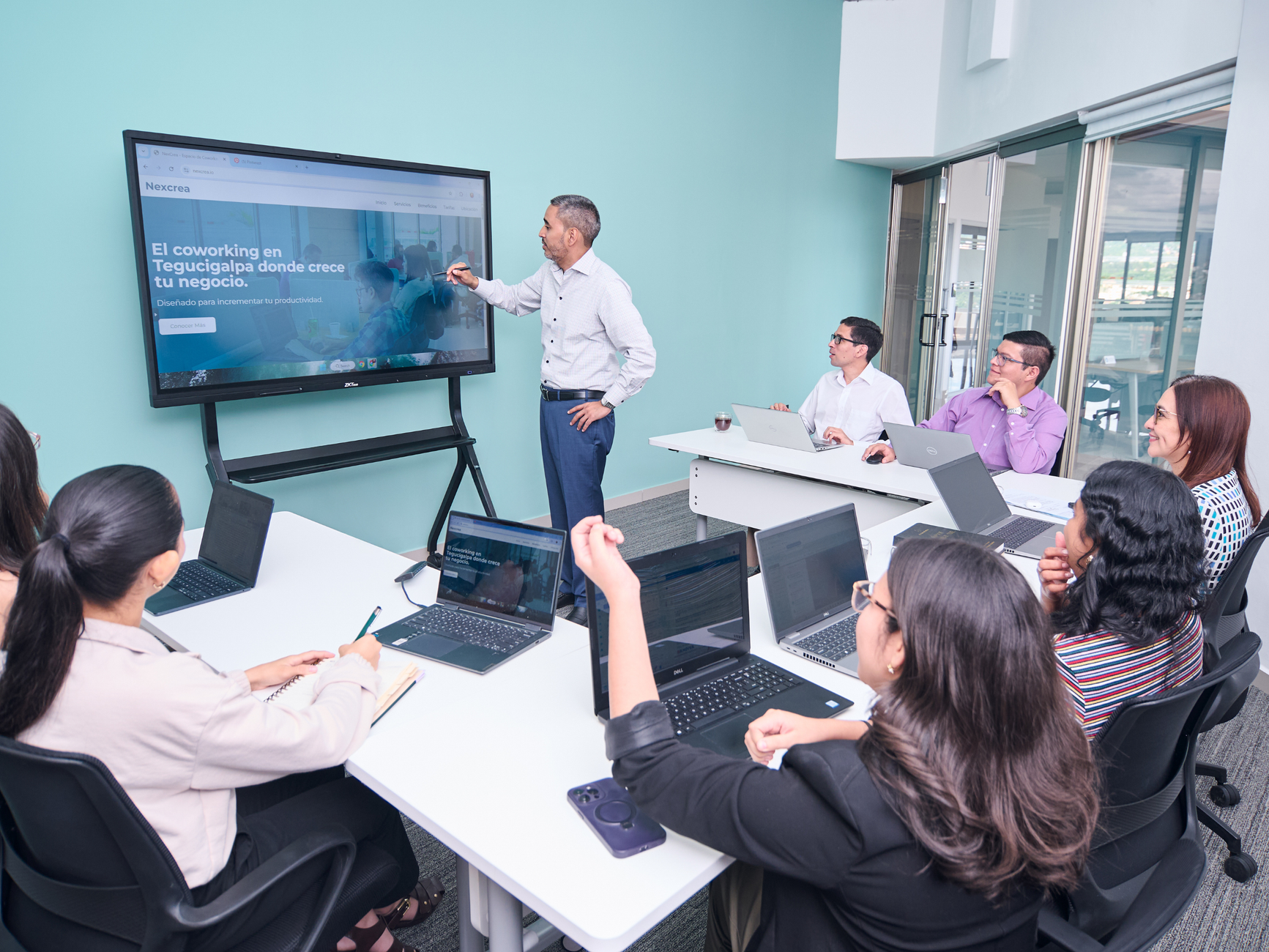 Tourism Destination Management — Professional team engaged in a business presentation with laptops and a projector screen.