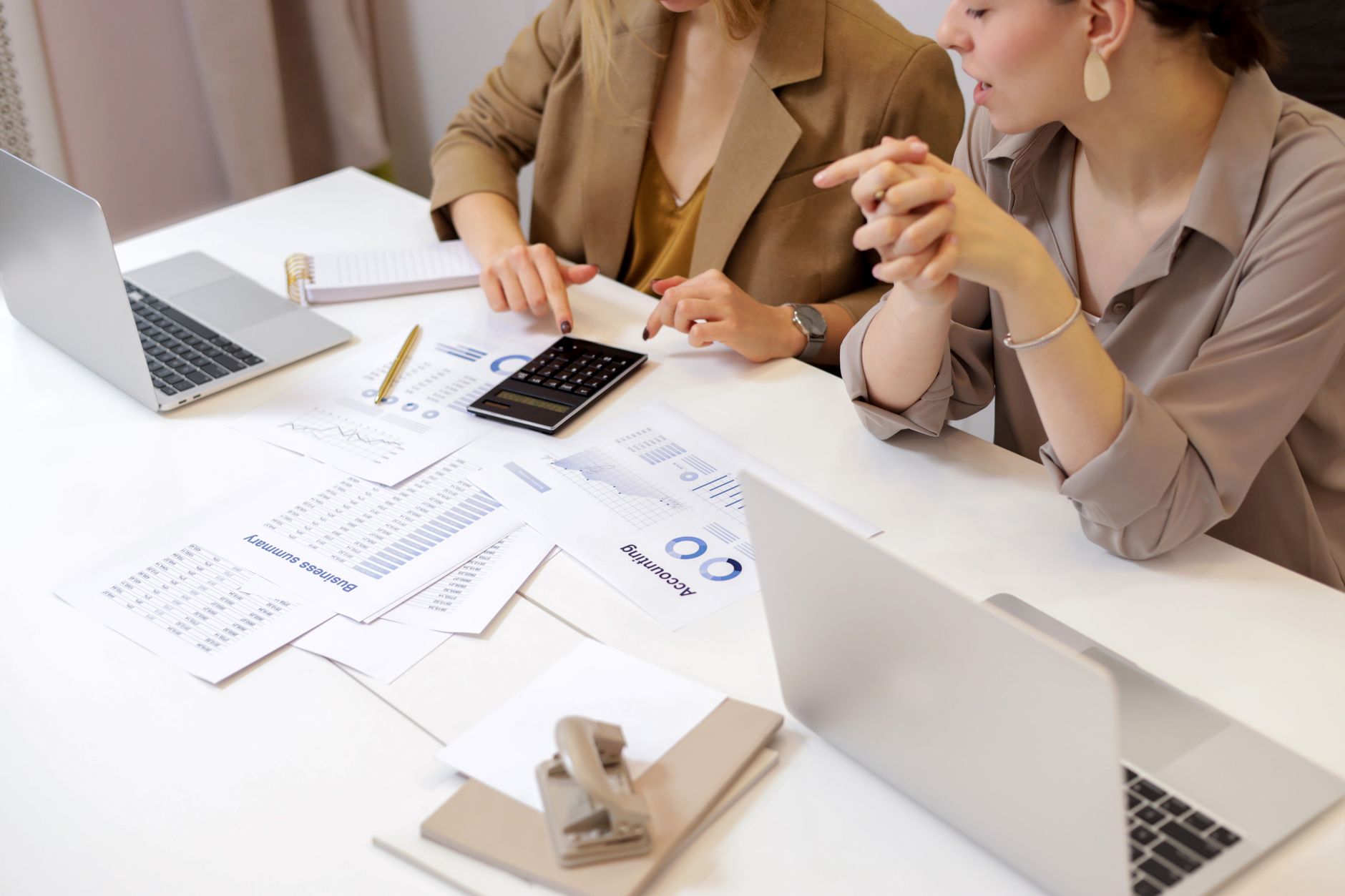 Accounting in a Business Context — Two professionals collaborating on financial documents in a modern office setting.