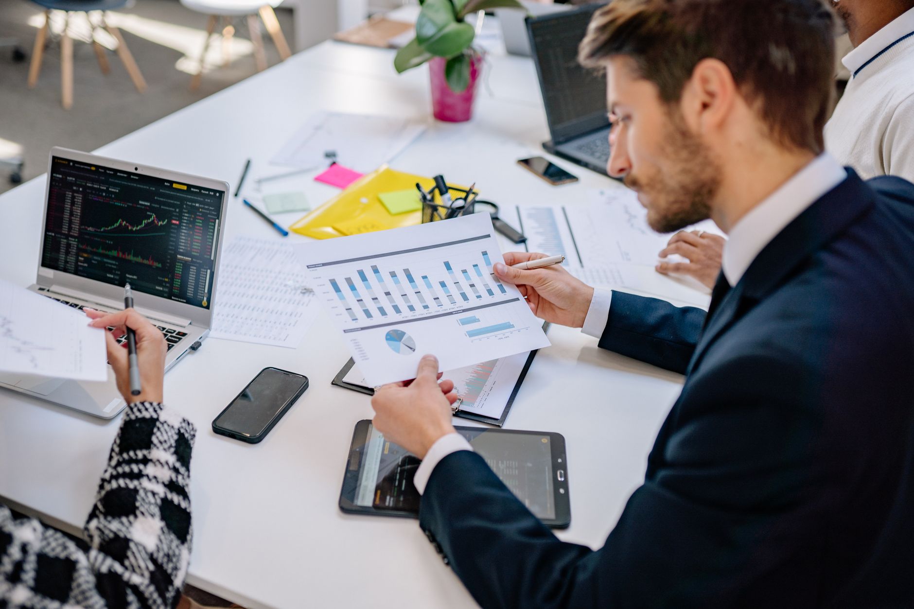 Financial Management — Business team reviewing graphs and data in an office setting.