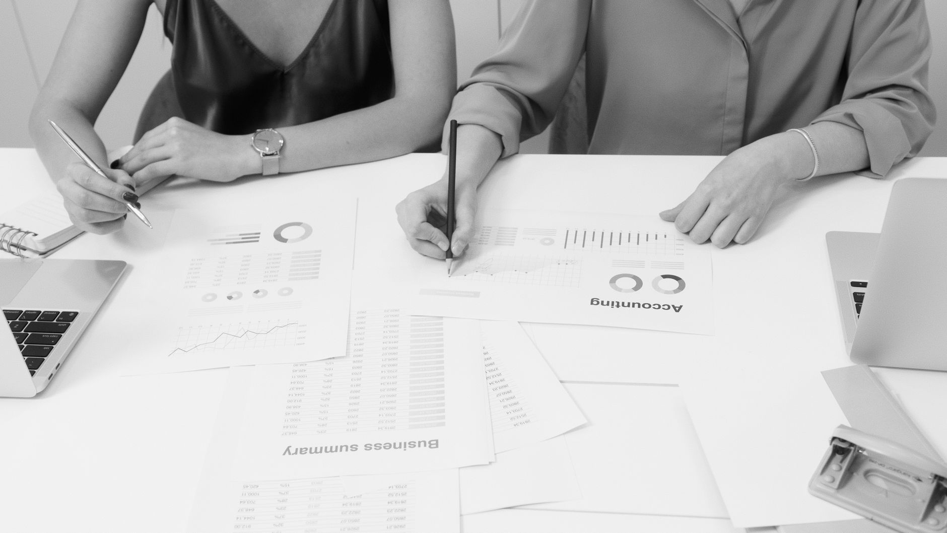 Accounting Methods — Two professionals analyzing financial documents in a modern office setting.
