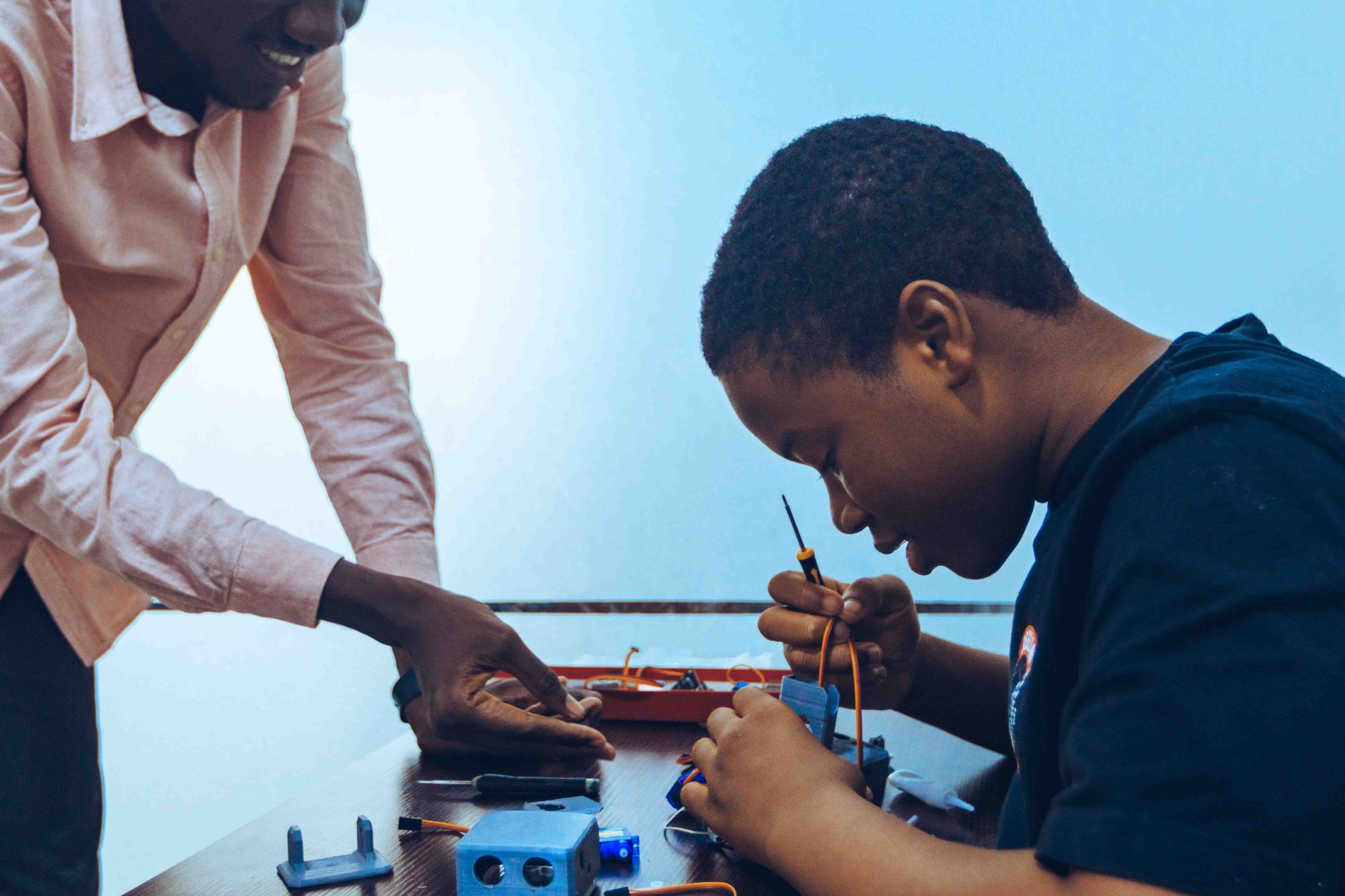 Foundation of Asset-based Lending — A student and a teacher engage in practical electronics learning in a classroom environment.