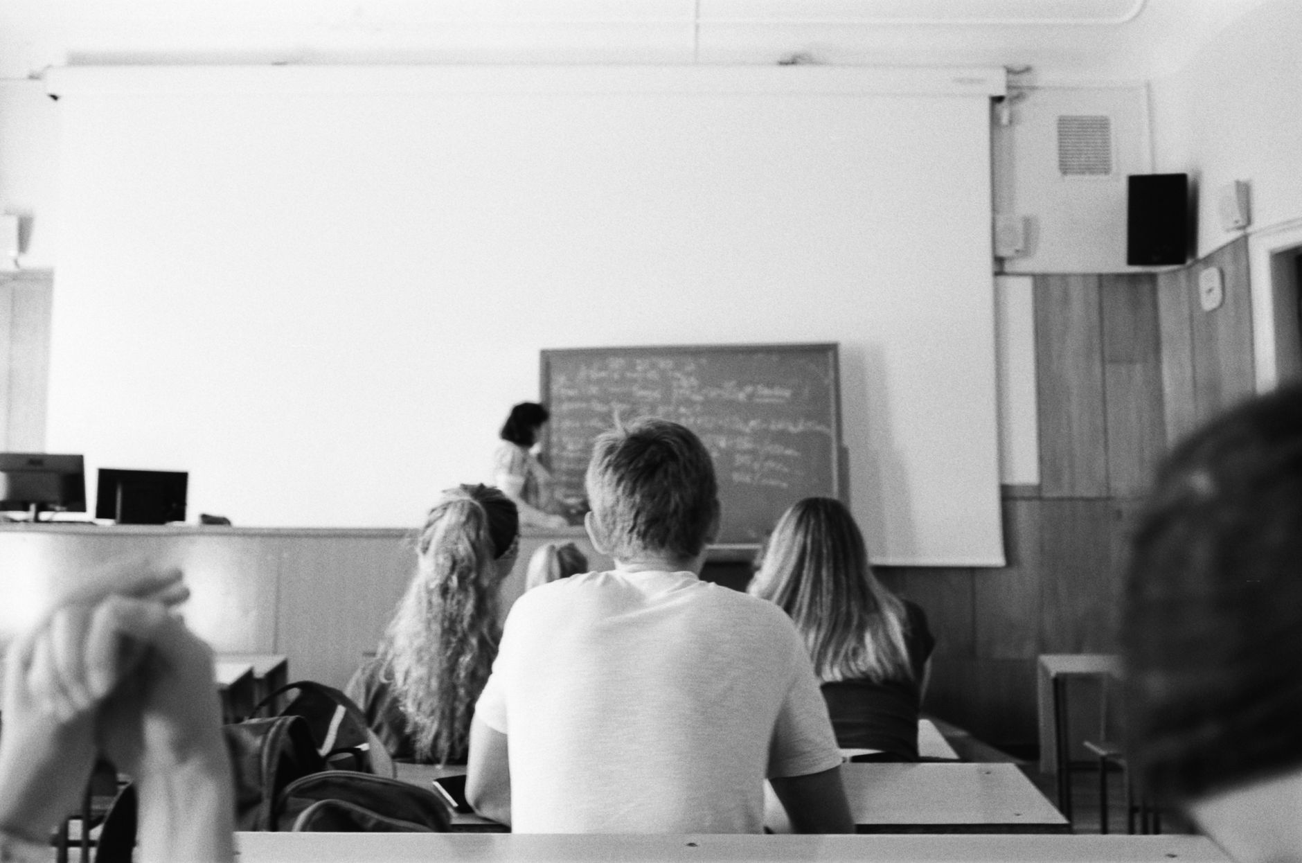 English for Higher Education — A black and white photo of students and teacher in a classroom setting, focused on learning.