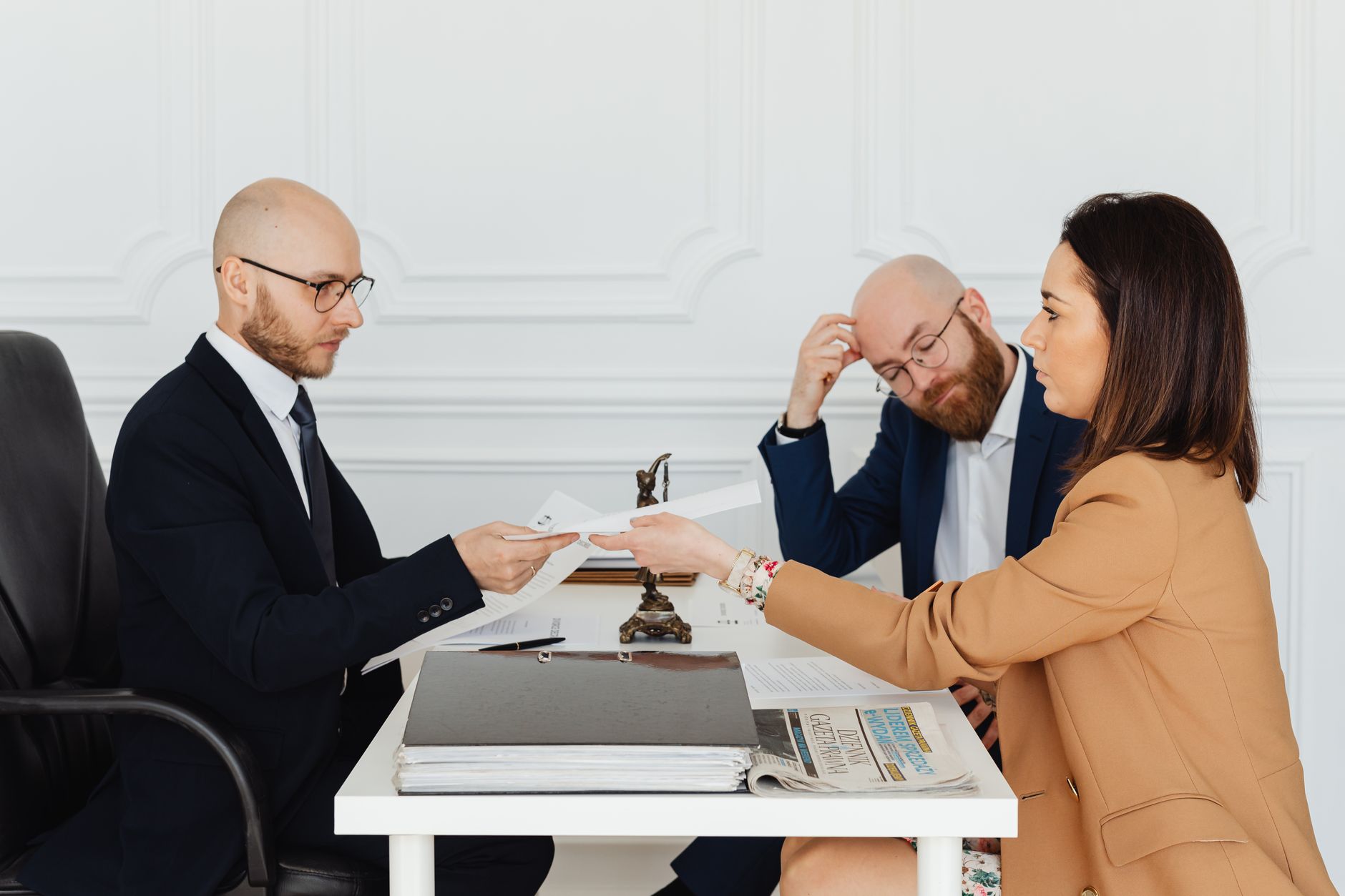 Legal Terminology and Communication — Professional meeting with lawyer and clients discussing documents in a modern office.