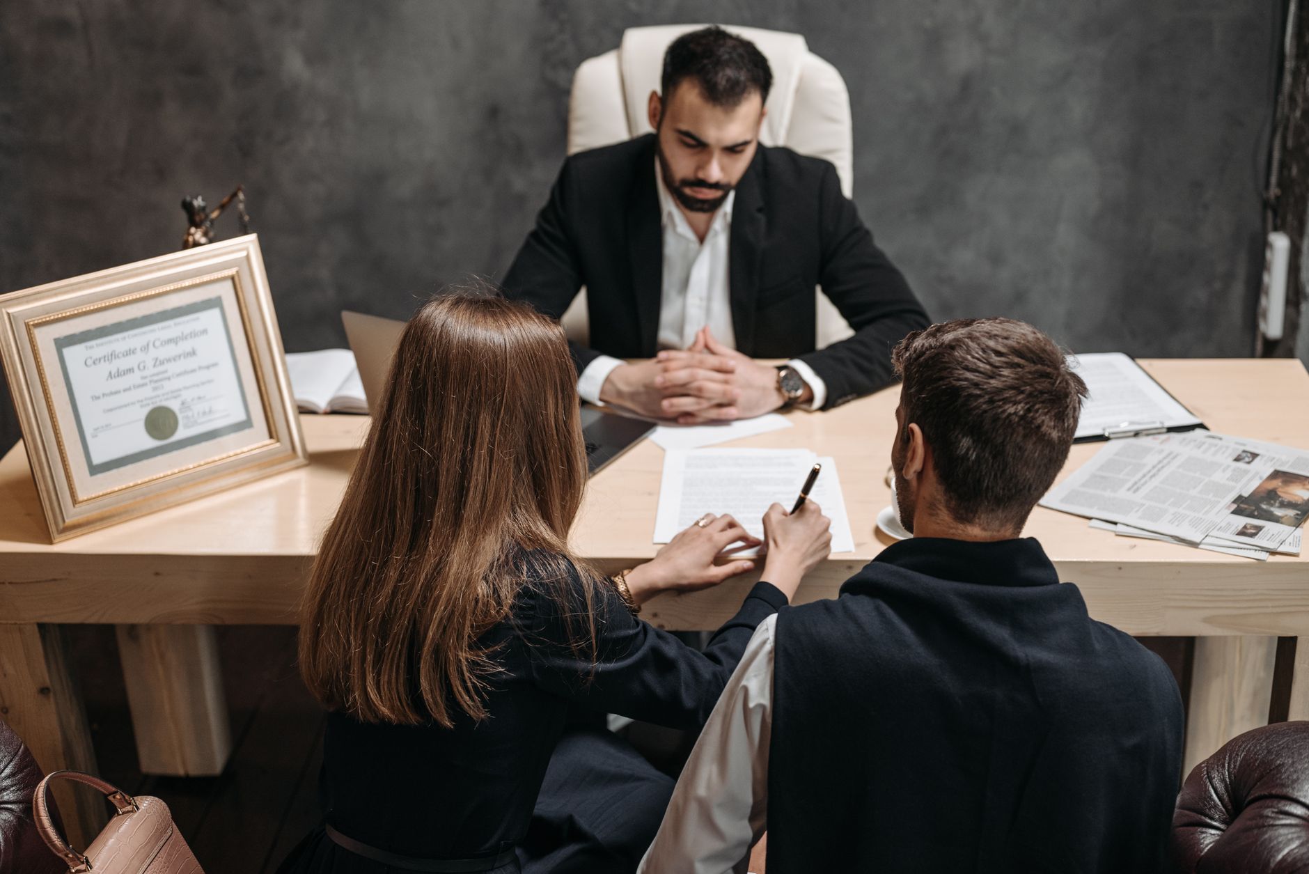 Contract Law and Disputes — A lawyer discusses legal documents with clients in an office setting.