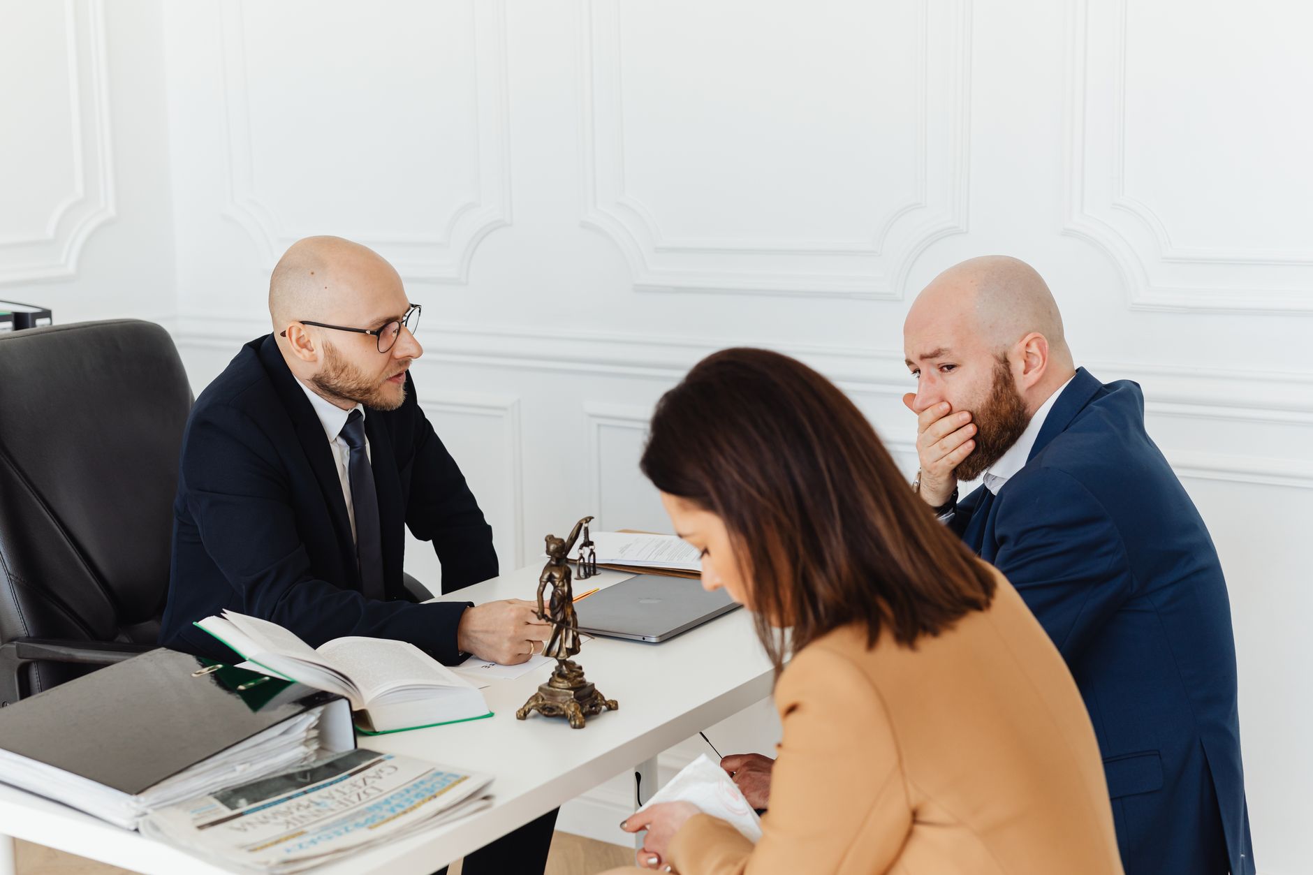 Public Law and Law of the European Union — A serious legal consultation in a professional office environment involving three adults.
