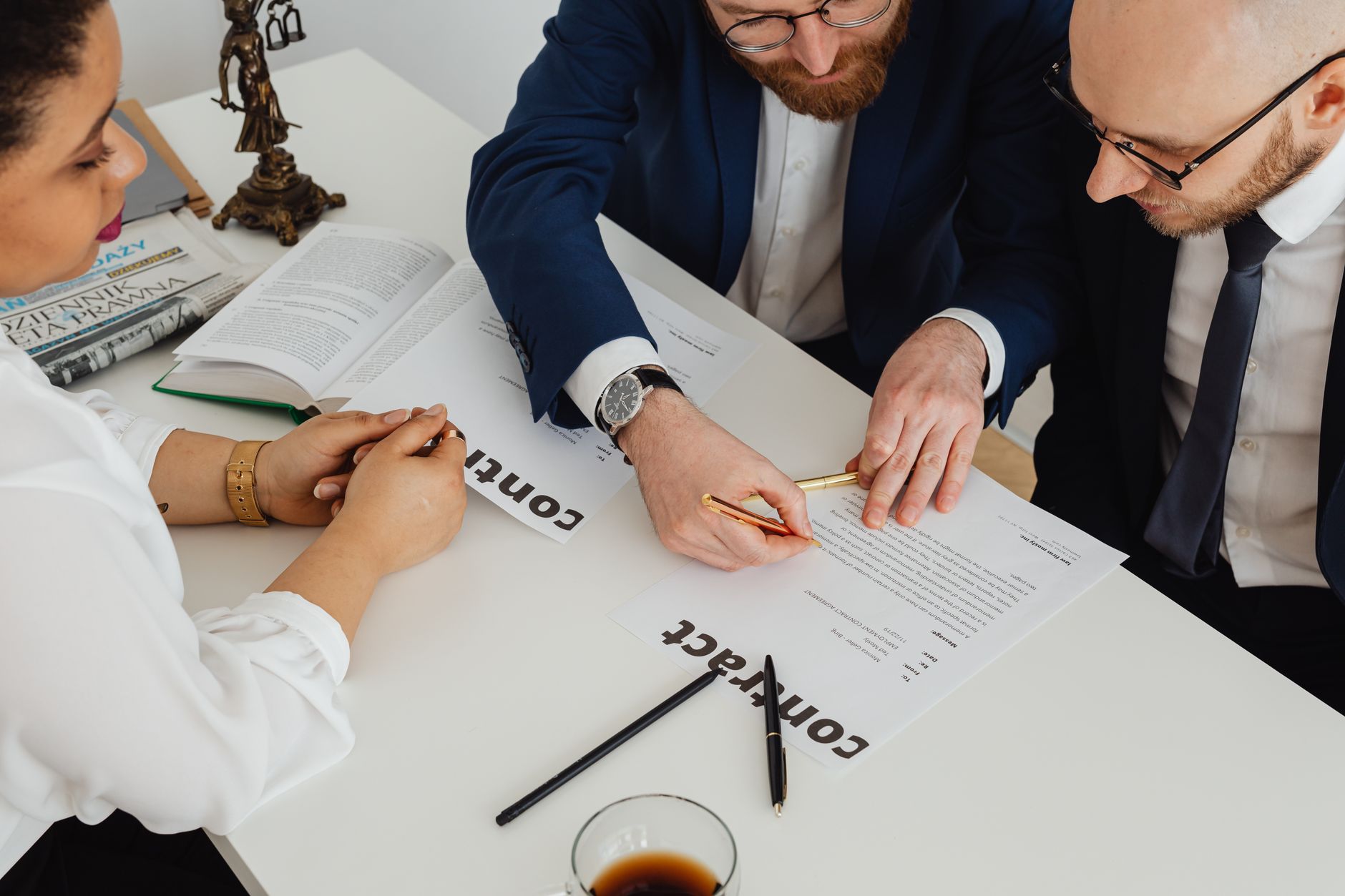 Commercial Trust Law — Business professionals engaged in contract review at a modern office desk.