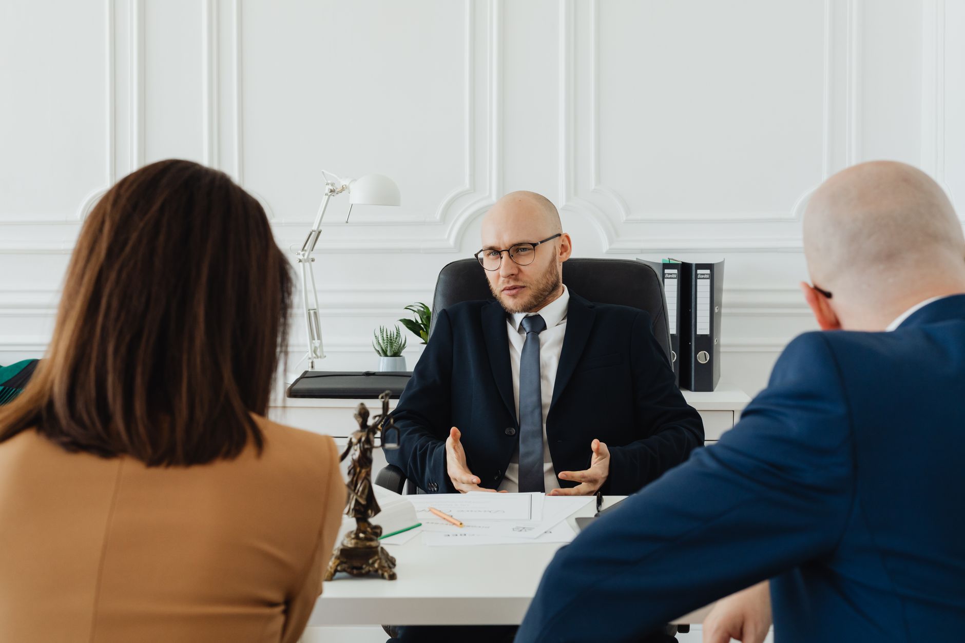 Law of Financial Crimes — A professional business meeting with a lawyer and clients in a modern office setting.