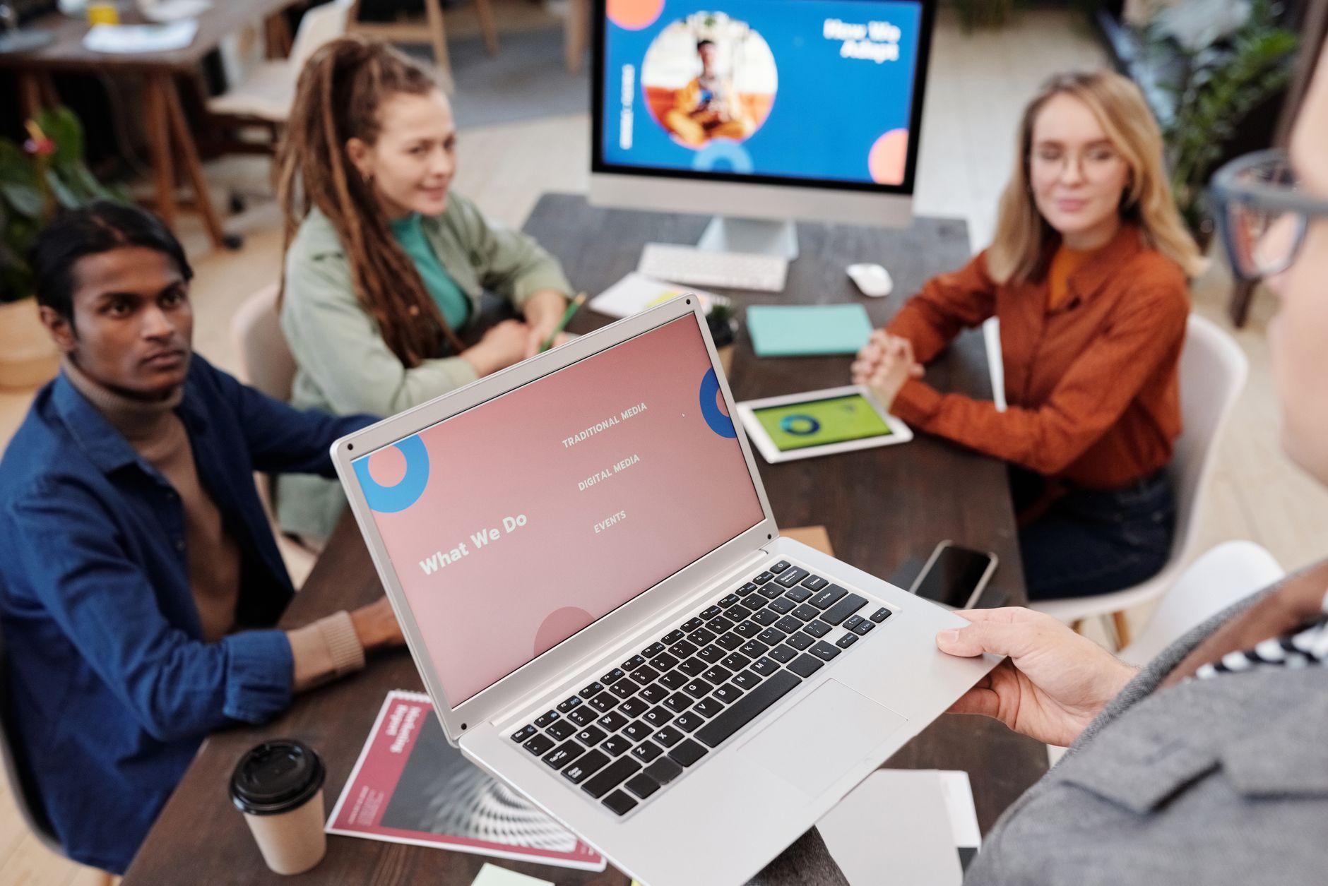 Elective Units — Team collaboration in an office setting with a laptop presentation and diverse colleagues.