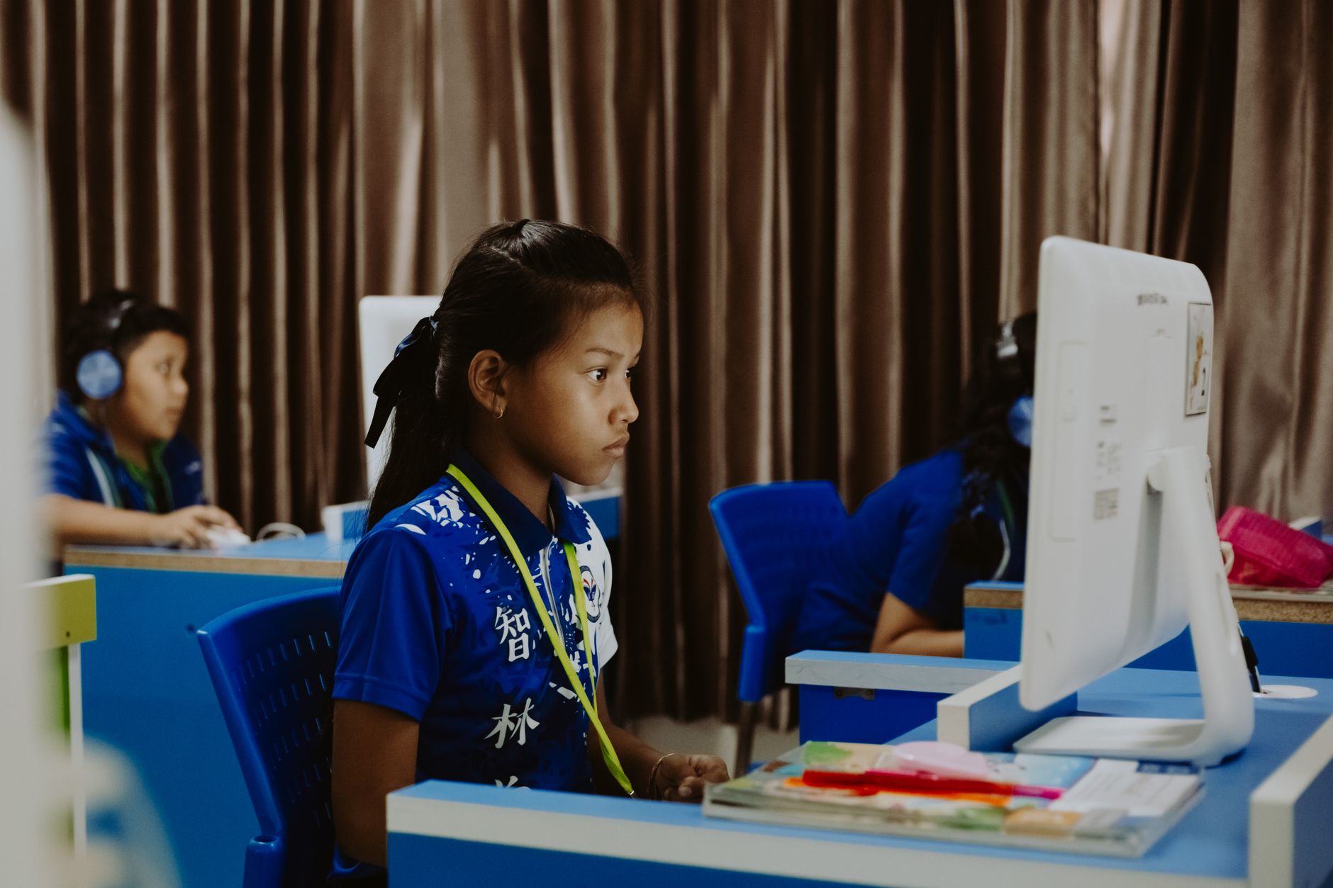 Embedded Technology Applications (Smart Home) — Young girls focused on learning in a computer lab, showcasing modern education.