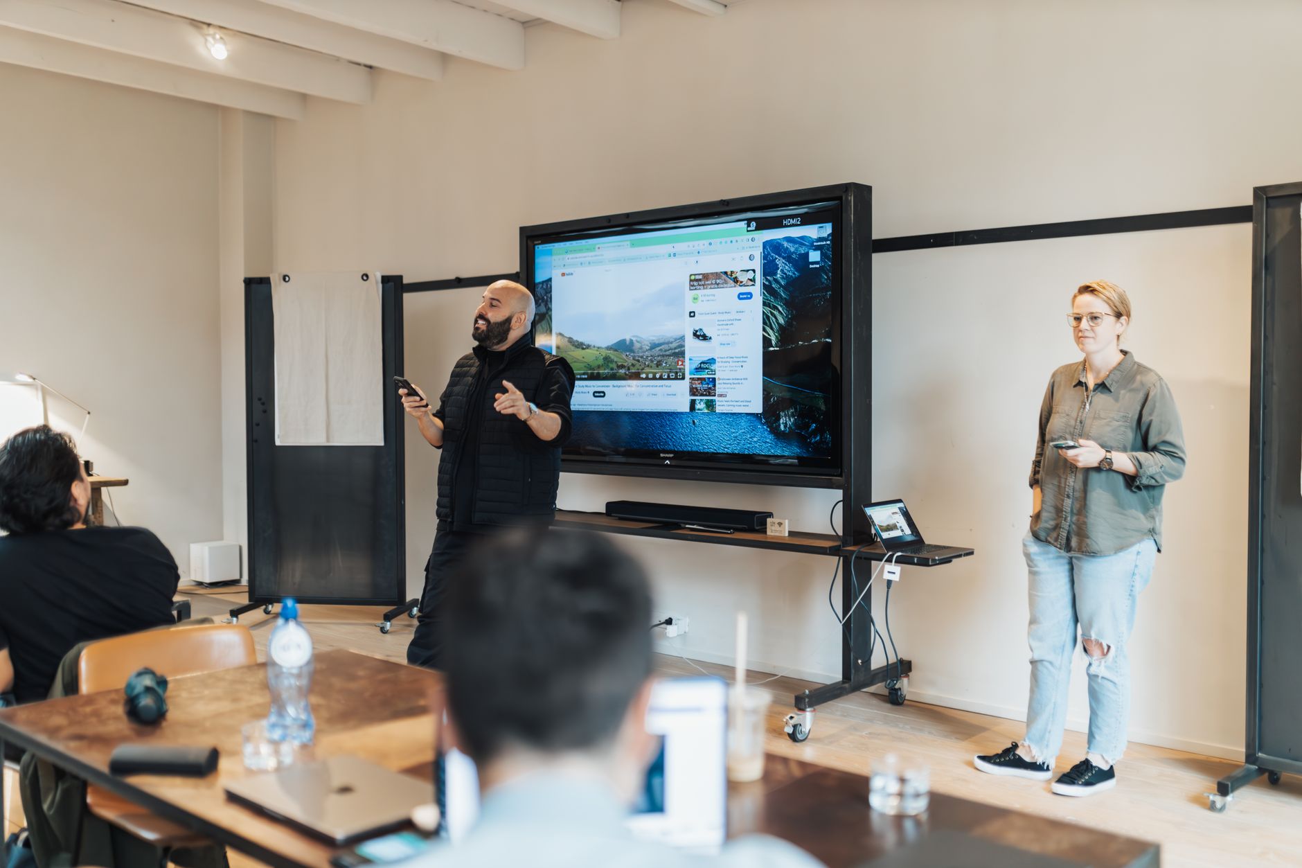 Content Management Systems — A team presentation in an office with a screen showcasing work-related material.