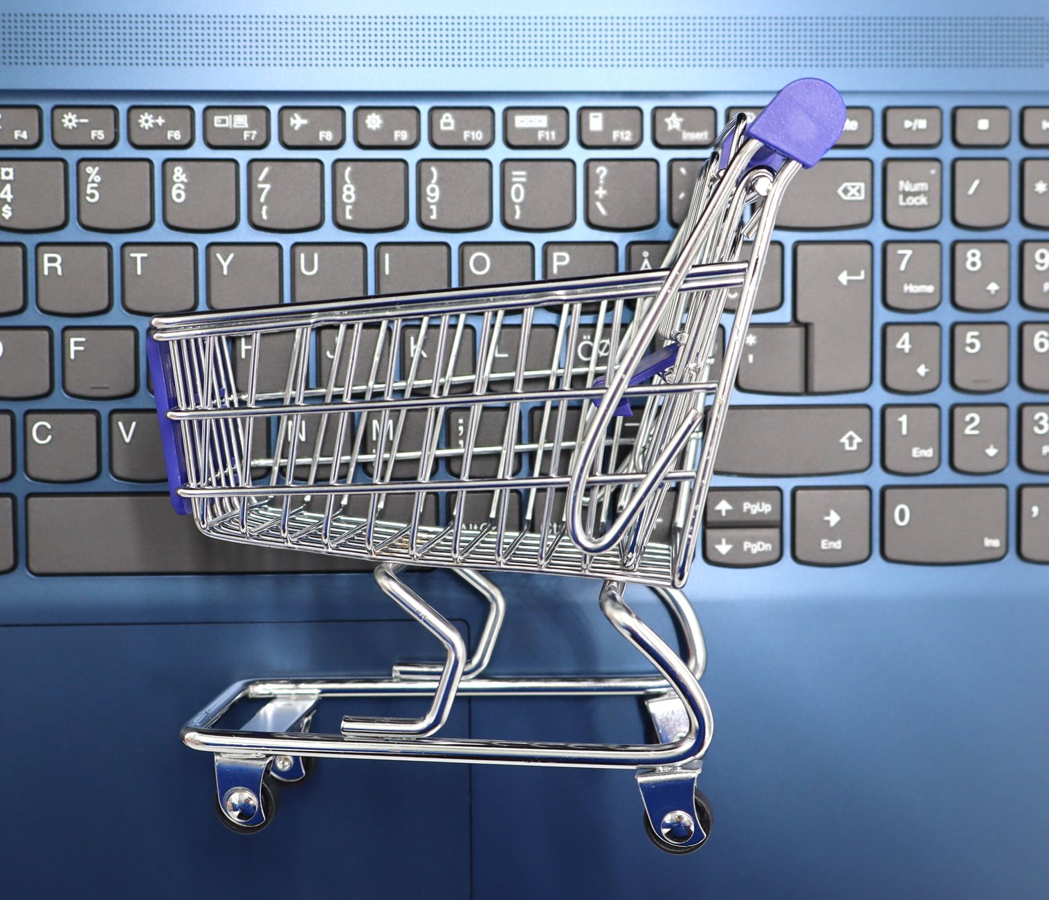 Business to Consumer (B2C) E-commerce — A miniature shopping cart placed on a laptop keyboard symbolizing online shopping and e-commerce.