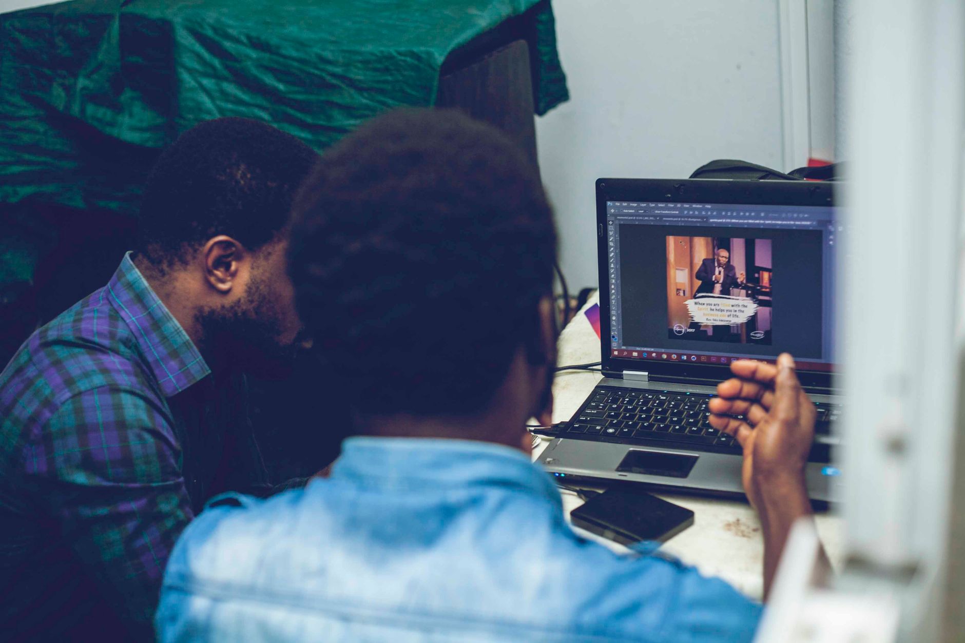 Computer Graphics Editing and Database Concepts — Two men collaborating on graphic design using a laptop indoors, focusing on technology and teamwork.