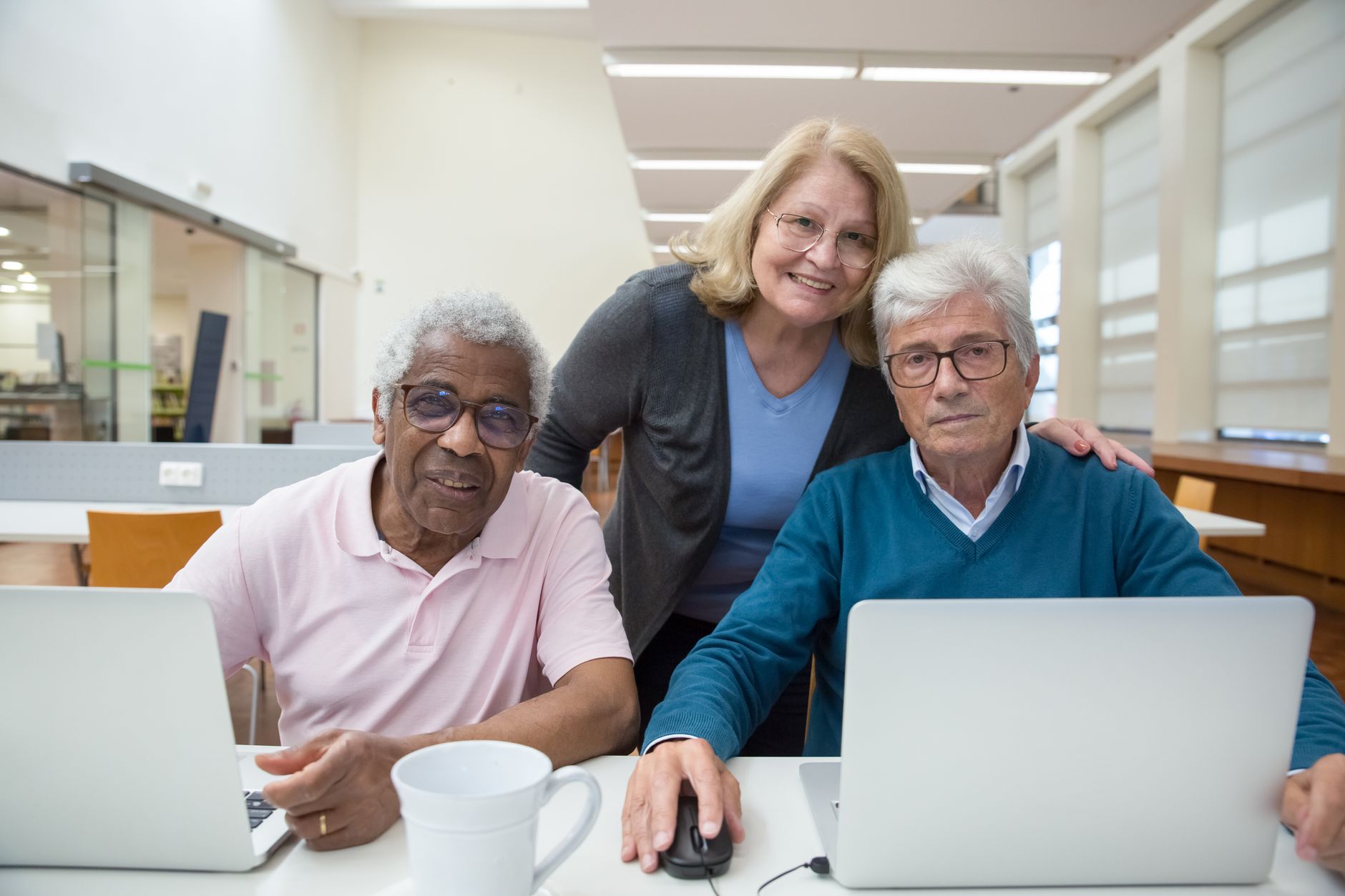 Network SecurityC#.NET Programming — Elderly adults learning and enjoying computer class together indoors.