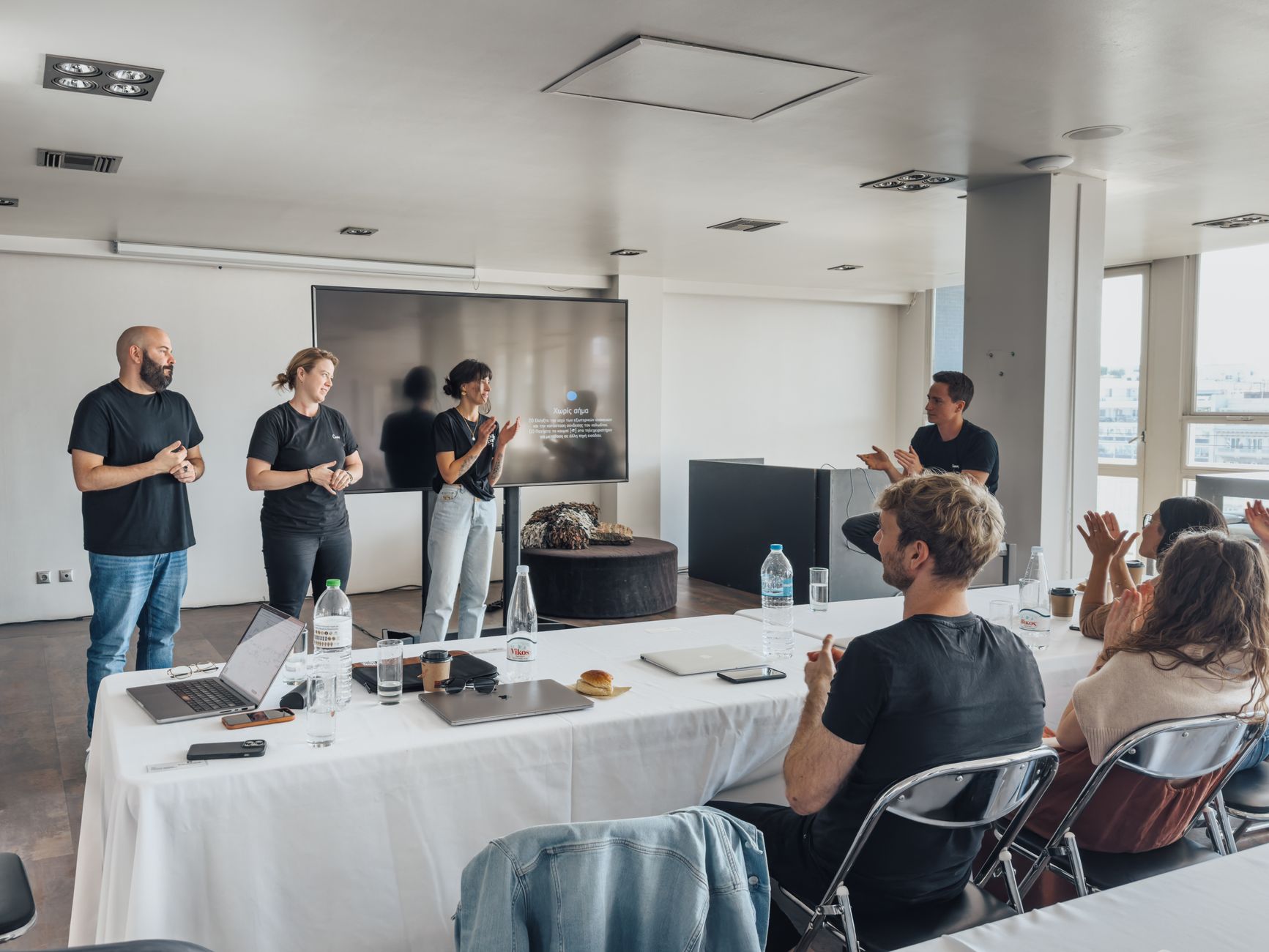 Content Management Systems — Team members presenting in a modern office with colleagues applauding.