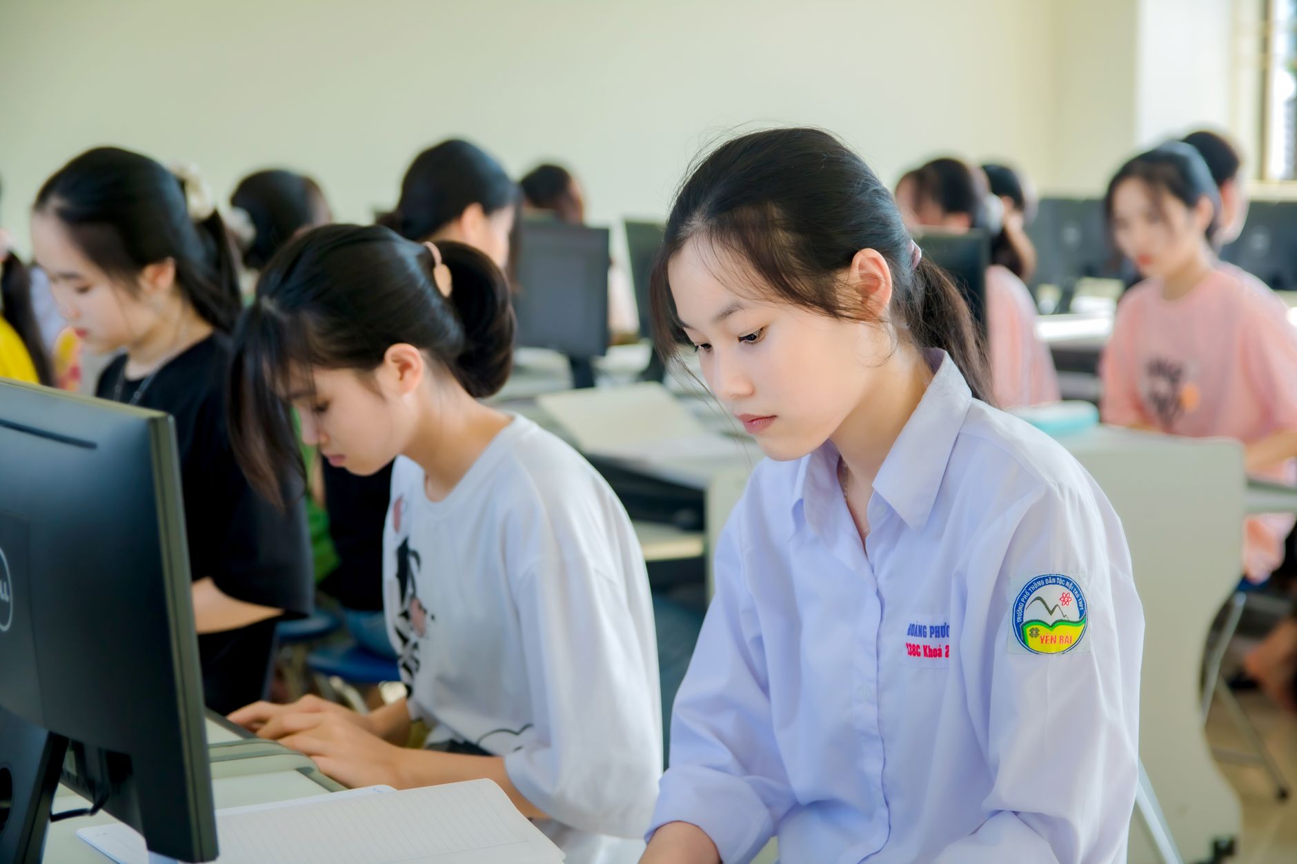 Security Strategy: Laws, Policies and Implementation — Young asian women focused on studying in a university computer lab.