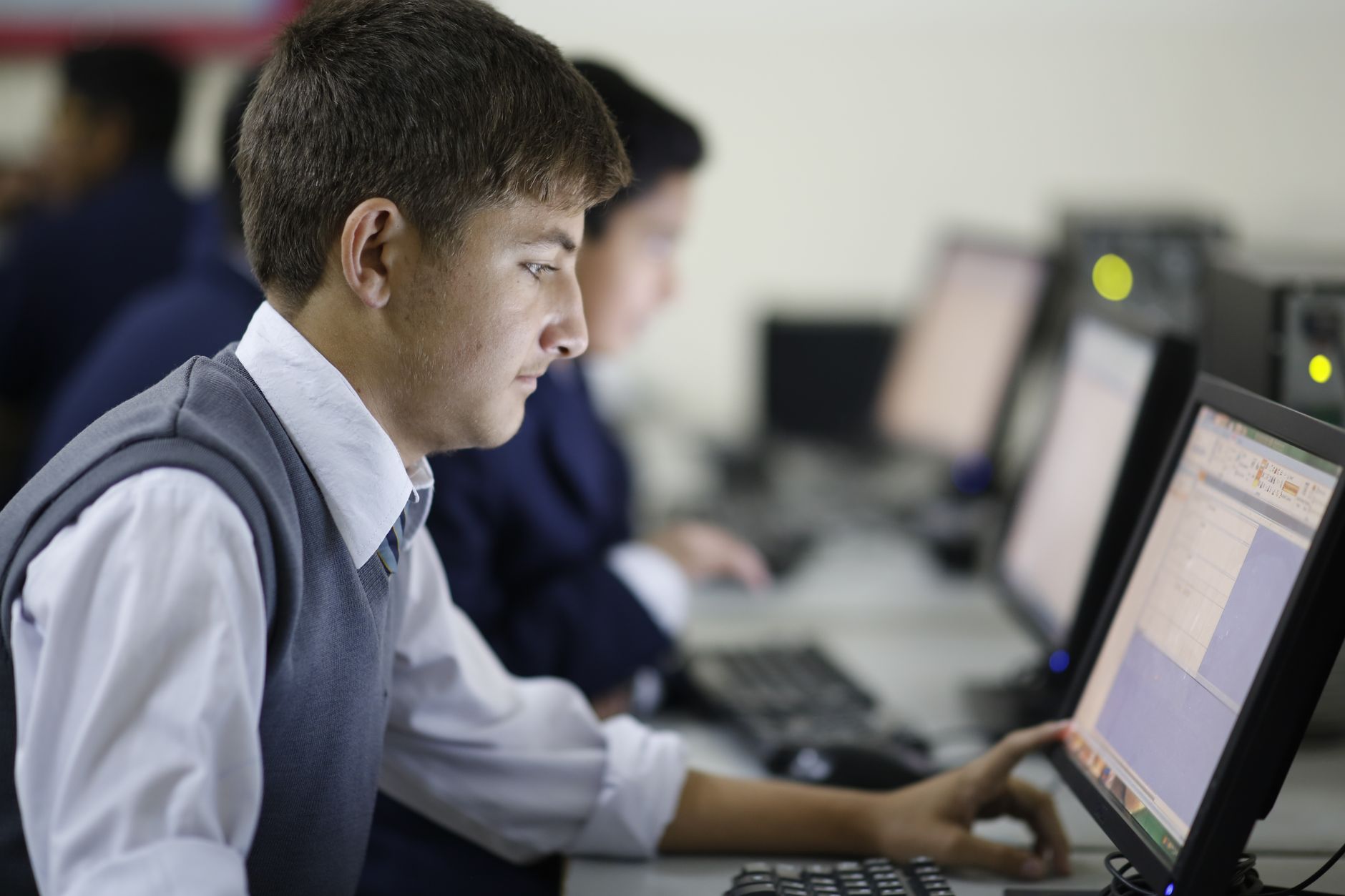 Critical Issues: Management of Supply Chains during Natural Disasters, Climate Change and Pandemics — Teenage student concentrating in computer lab using a desktop computer at school.