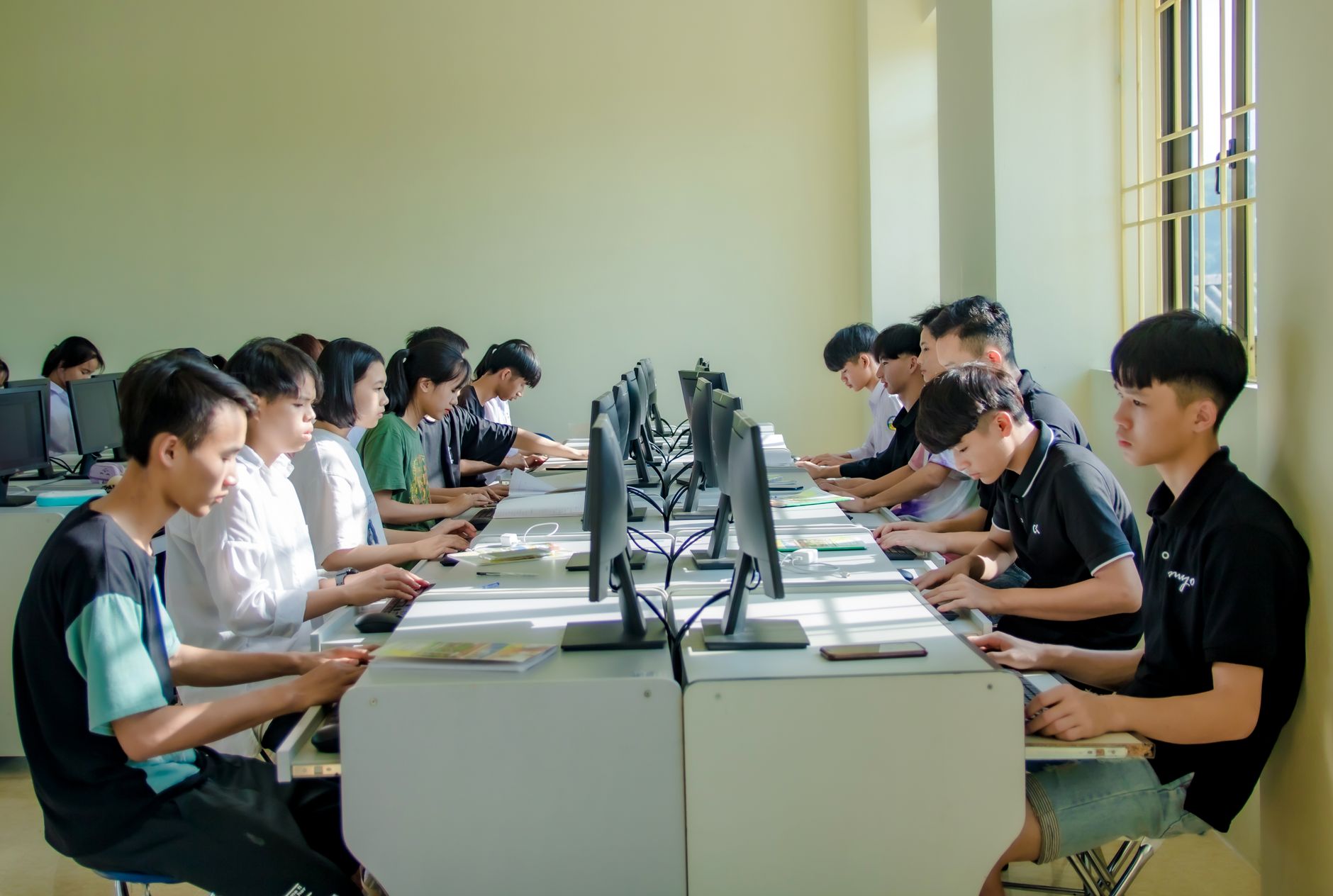 Physical activity and nutrition co-ordination (PANCo) in early years — A group of students in a classroom focused on computer screens, fostering digital education.