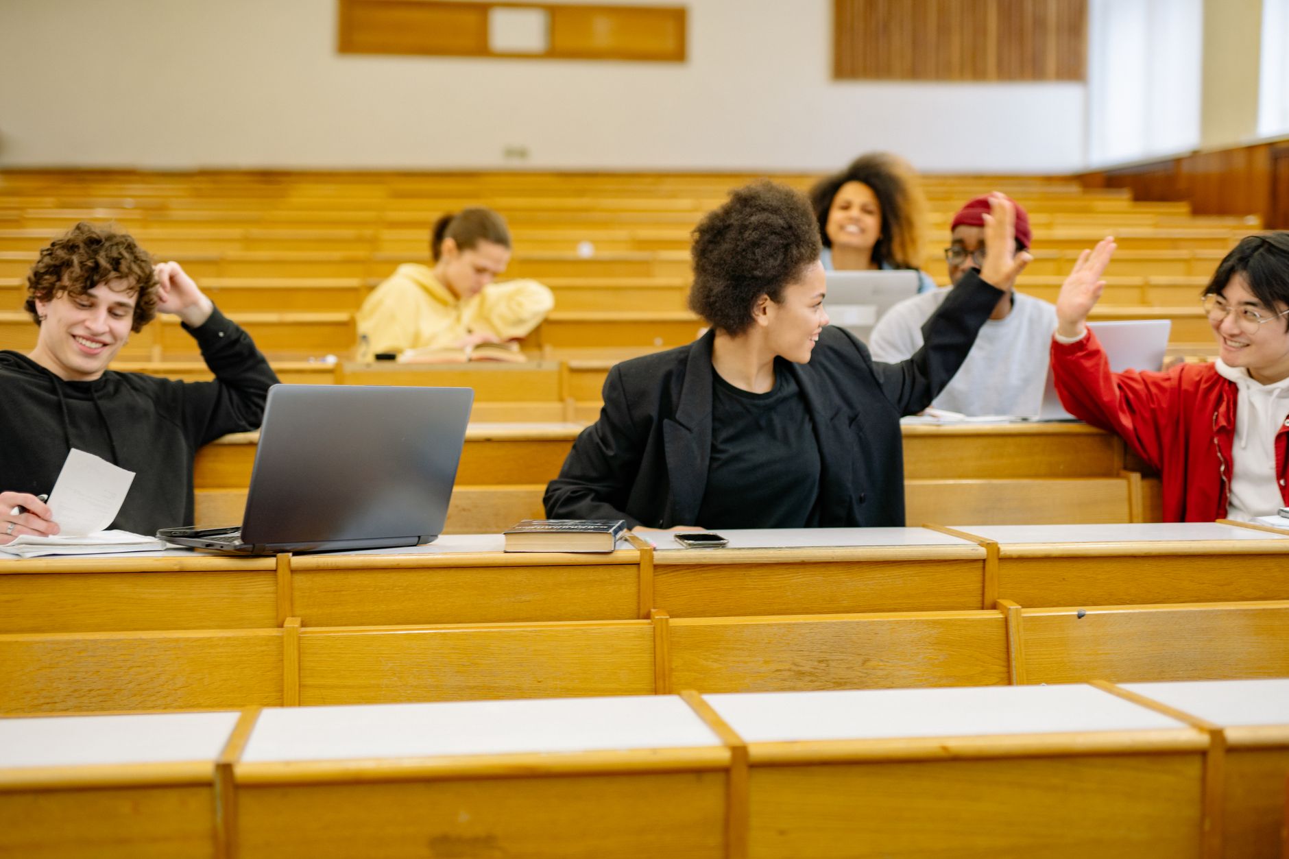 Children’s well-being and resilience — Group of diverse university students interacting and studying in a classroom setting.