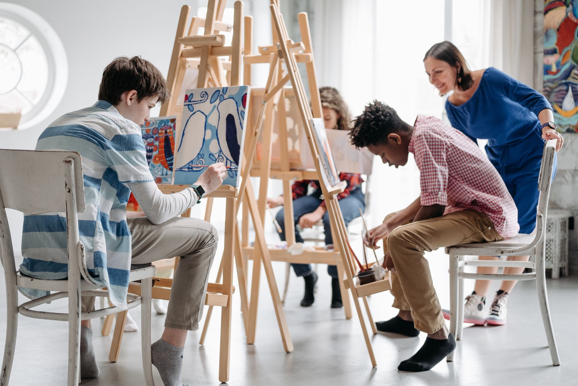 Action Research — Children painting in a classroom with teacher guidance, focusing on creativity and learning.