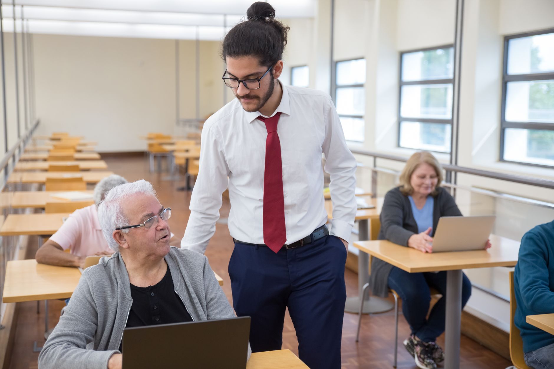 Inclusive Practice — Group of seniors learning computer skills in a portugal classroom setting.