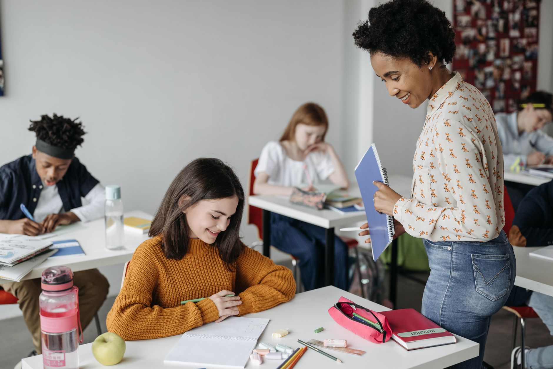 Research Methods in Education — Teacher assisting students in a classroom setting, fostering a learning environment.
