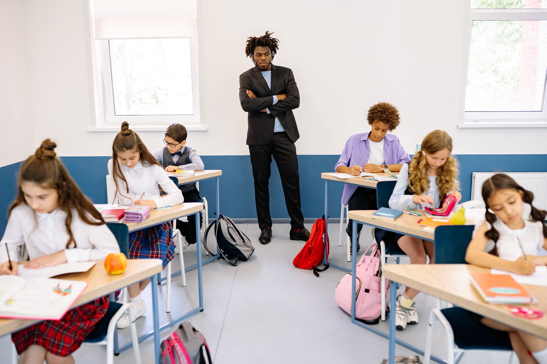 An Introduction to Lesson Planning — Elementary students engaged in learning with a teacher overseeing in a bright classroom.