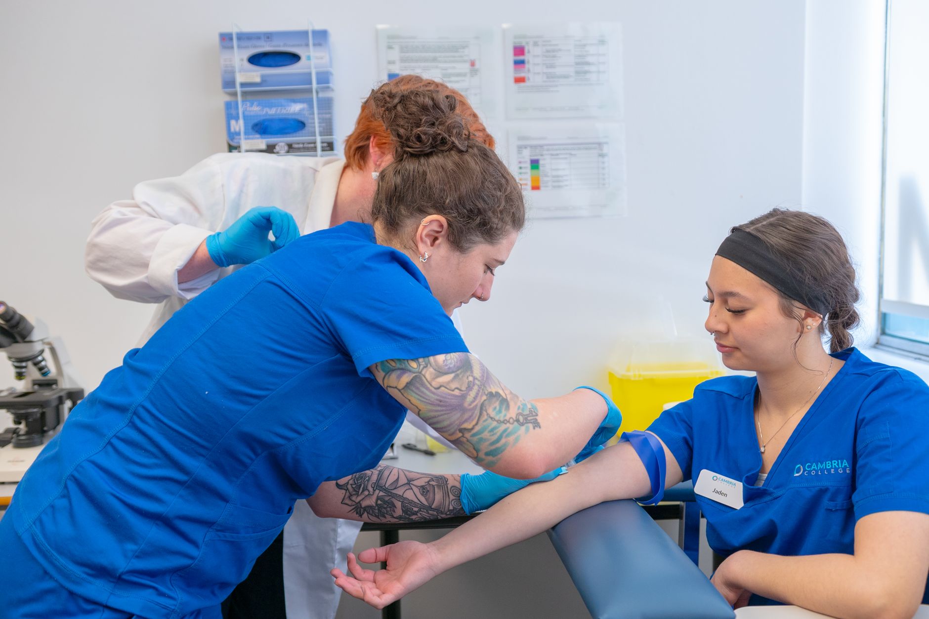 Health Coaching in Action — Nursing students practice blood draw techniques under supervision in a clinical lab.