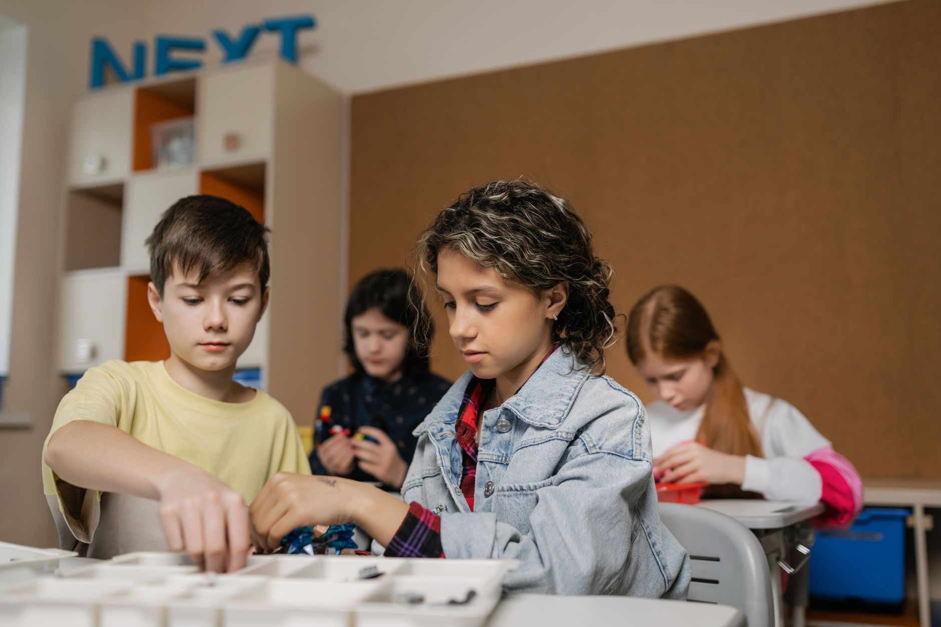 Early Years Pedagogy — Children collaborating on robotics project in a classroom setting, fostering technology learning.