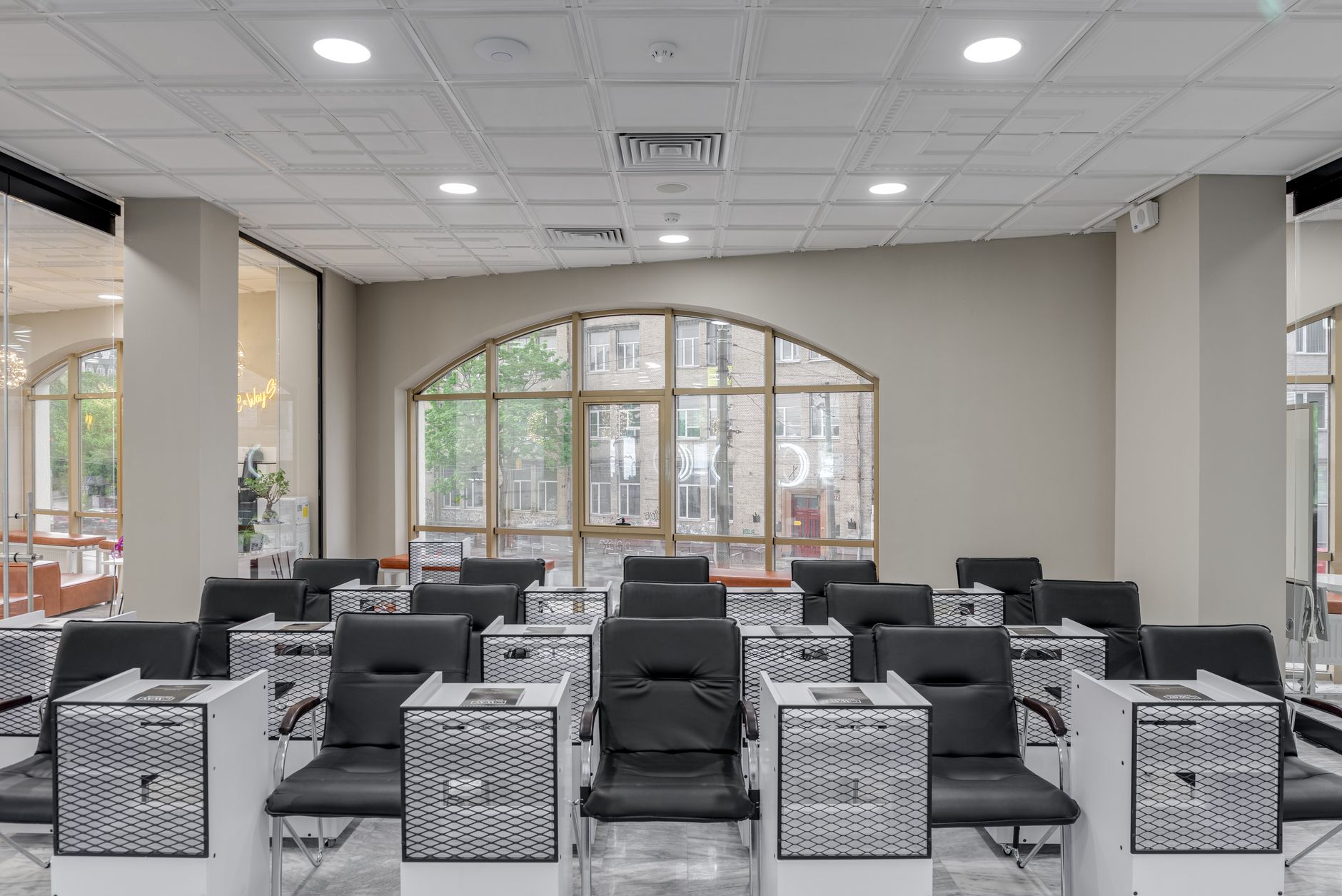 Health, safety and hygiene for aesthetic procedures — Spacious salon with black leather chairs and large glass windows for natural light.