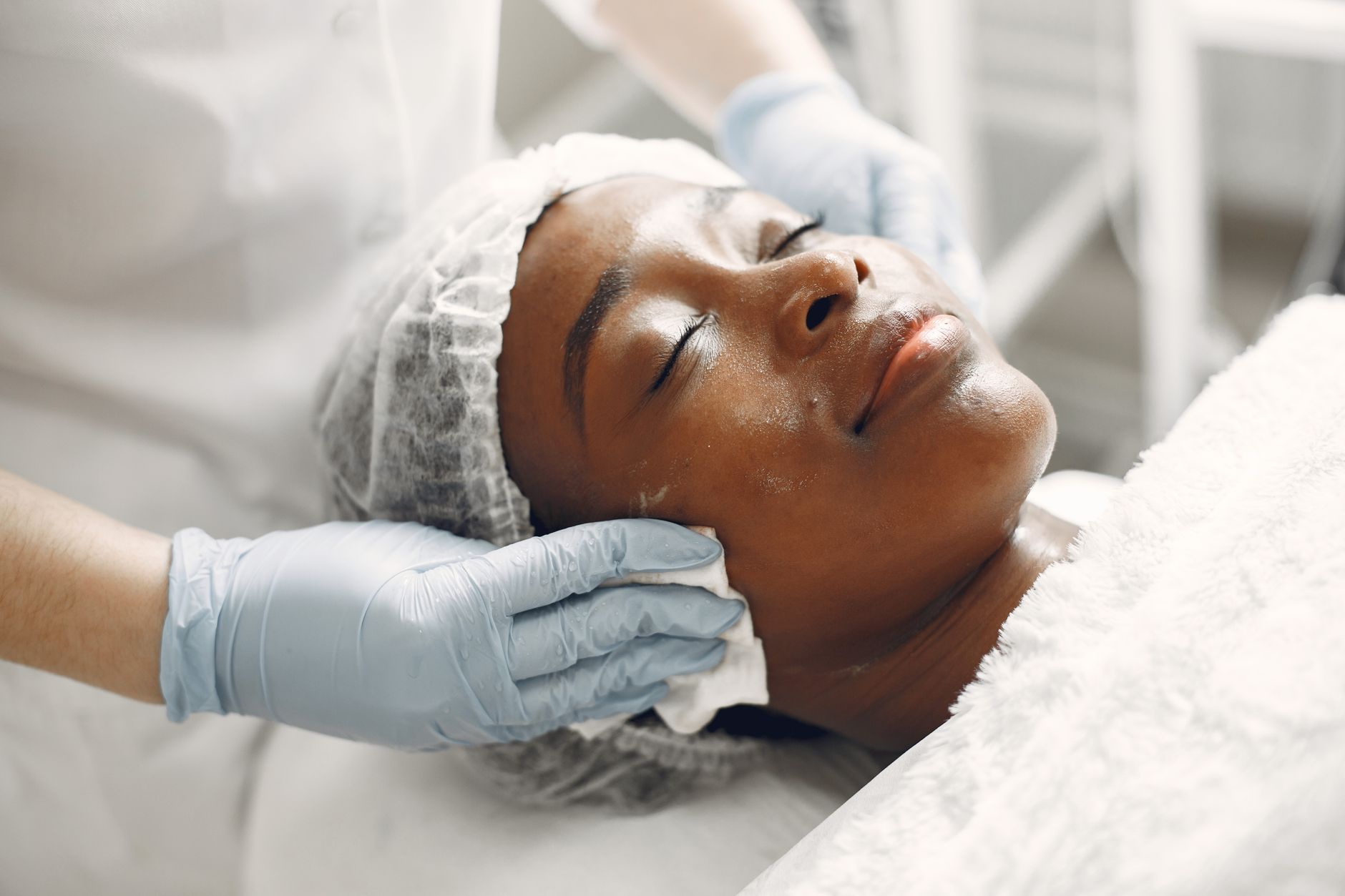 Skin rejuvenation using microneedling — A woman receiving a gentle facial treatment during a spa session for skincare and relaxation.
