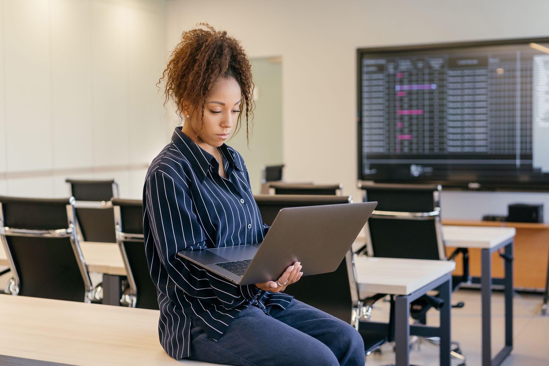 unit – 1 credit.: — African american woman with curly hair working on a laptop in a modern office setting.