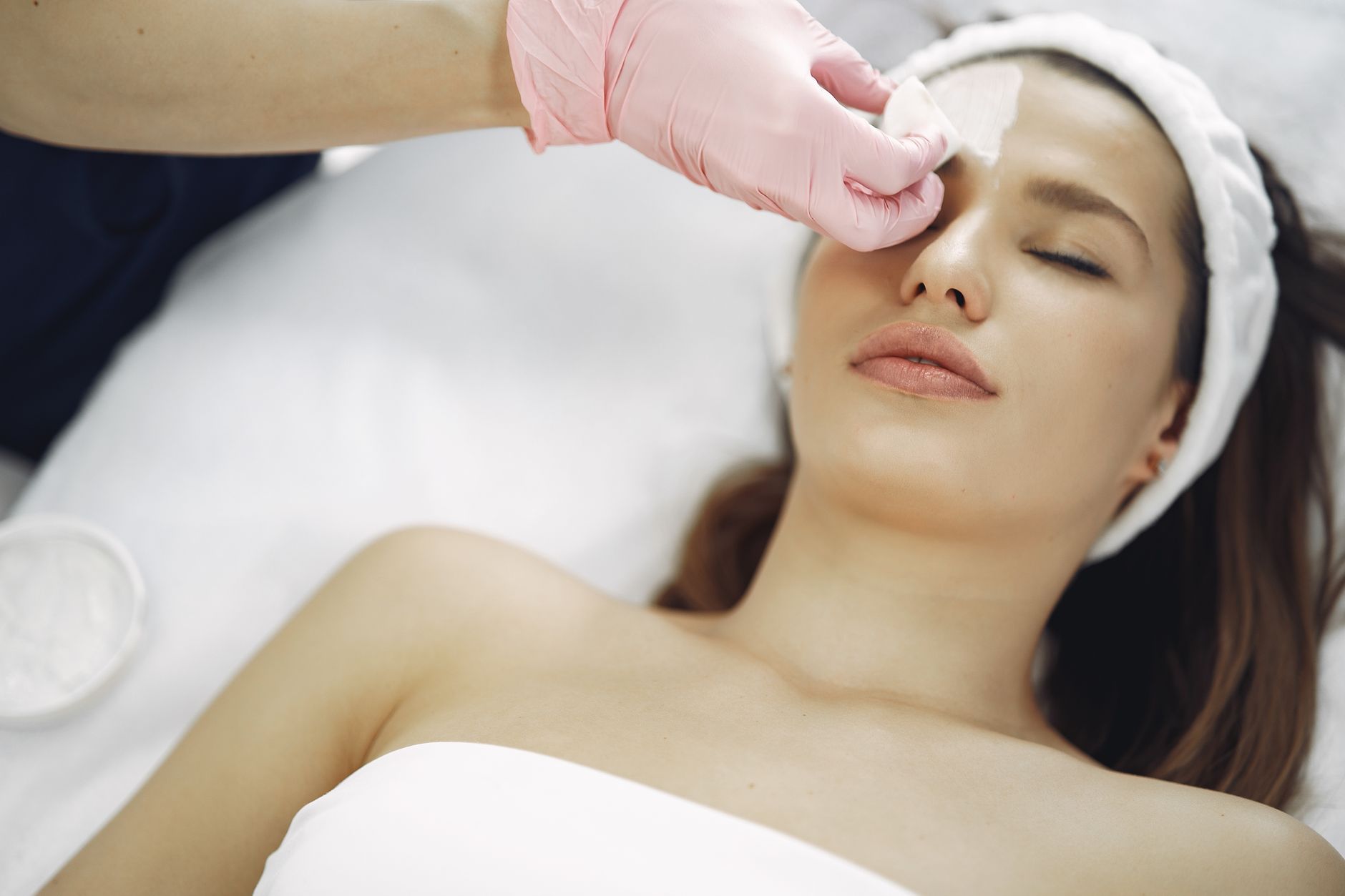 Skin rejuvenation using a plasma device — A woman enjoys a soothing facial treatment at a spa, promoting relaxation and skincare.