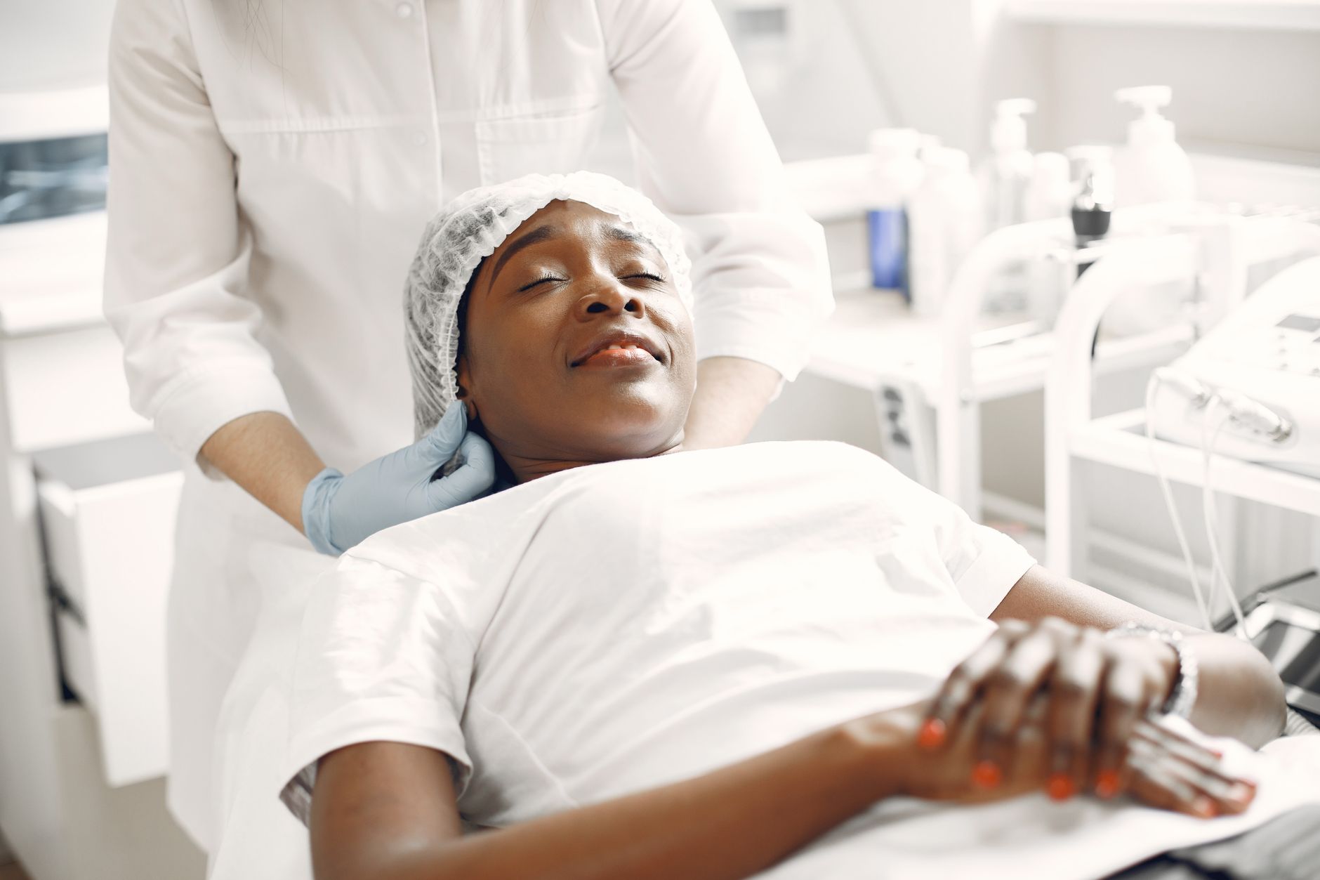 Skin rejuvenation using microneedling — A woman enjoying a relaxing facial massage in a modern aesthetic clinic setting.
