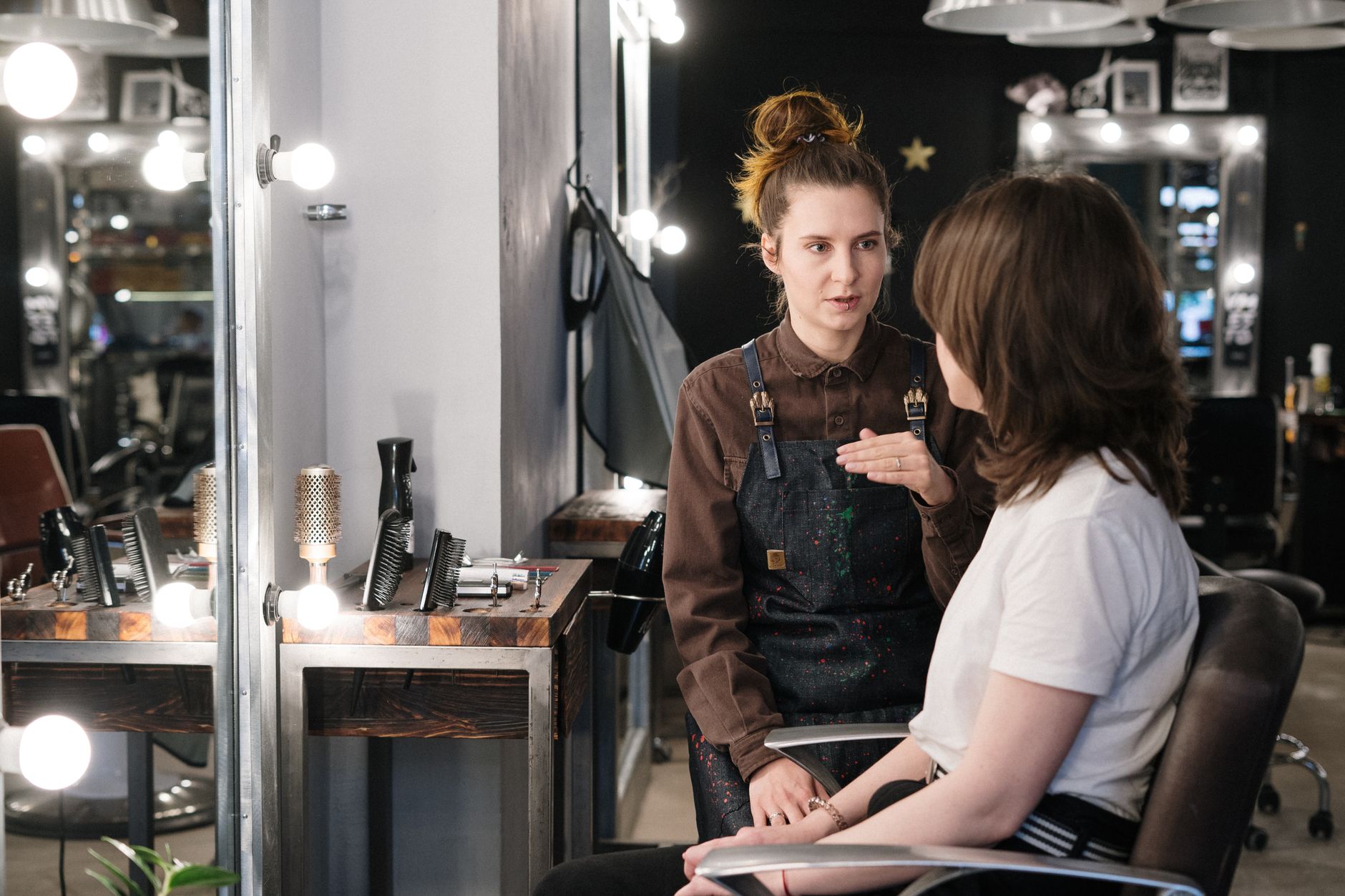 Needlestick Injury, Infection Prevention and Control — Hair stylist providing consultation to client in a modern salon setting.