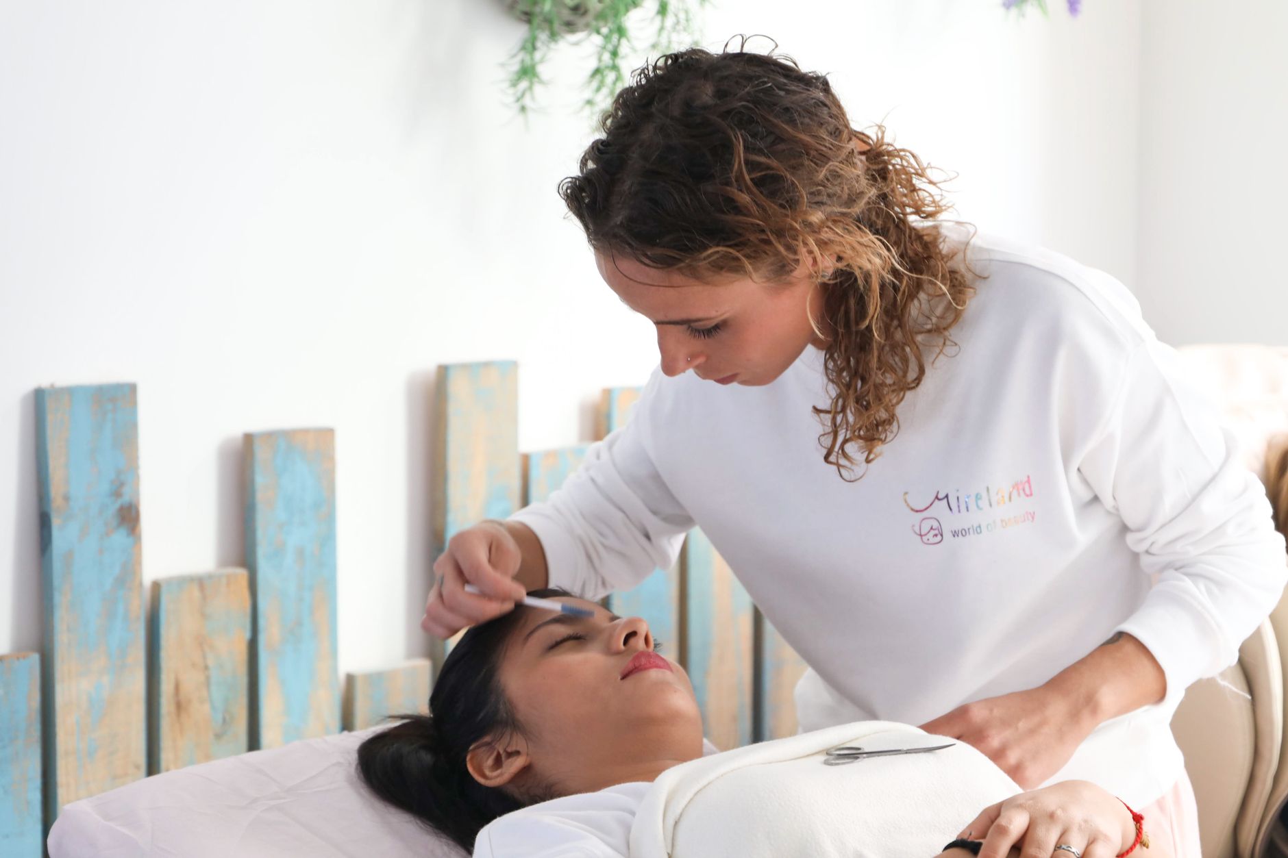 Professional Principles and Ethical and Environmental Sustainability Working Collaboratively with Healthcare and Other Professionals — Aesthetician performs a soothing facial on a client at serene spa.