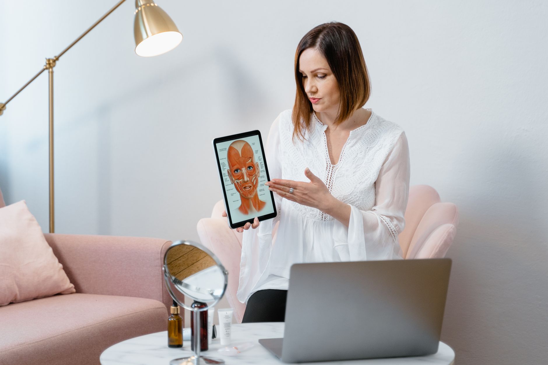 Consultation and Advanced Skin Analysis using Technologies — Professional woman explaining facial anatomy using a digital tablet in a modern office setting.