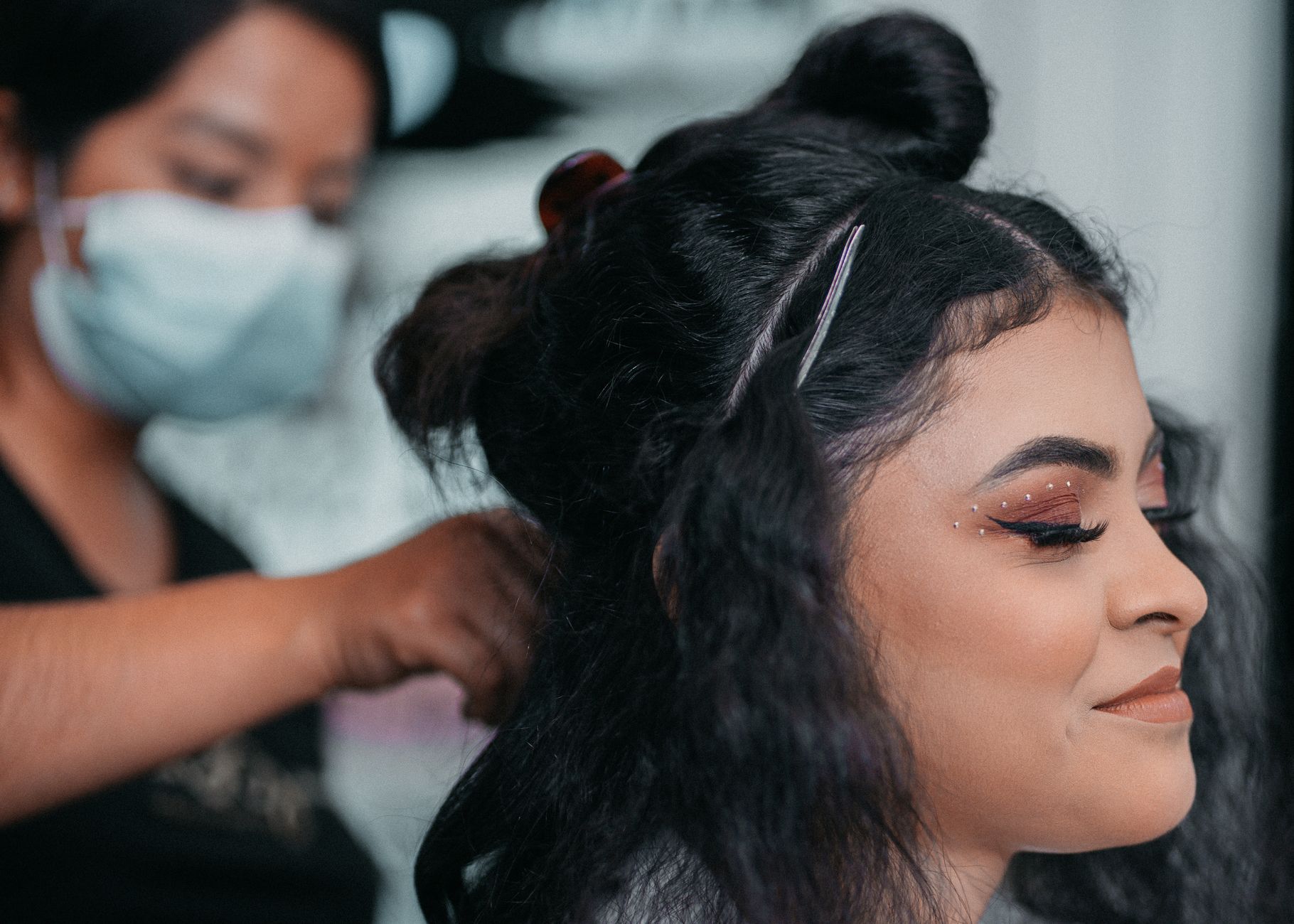 unit – 8 credits — Close-up of professional hair styling at a salon with a focus on makeup artistry.