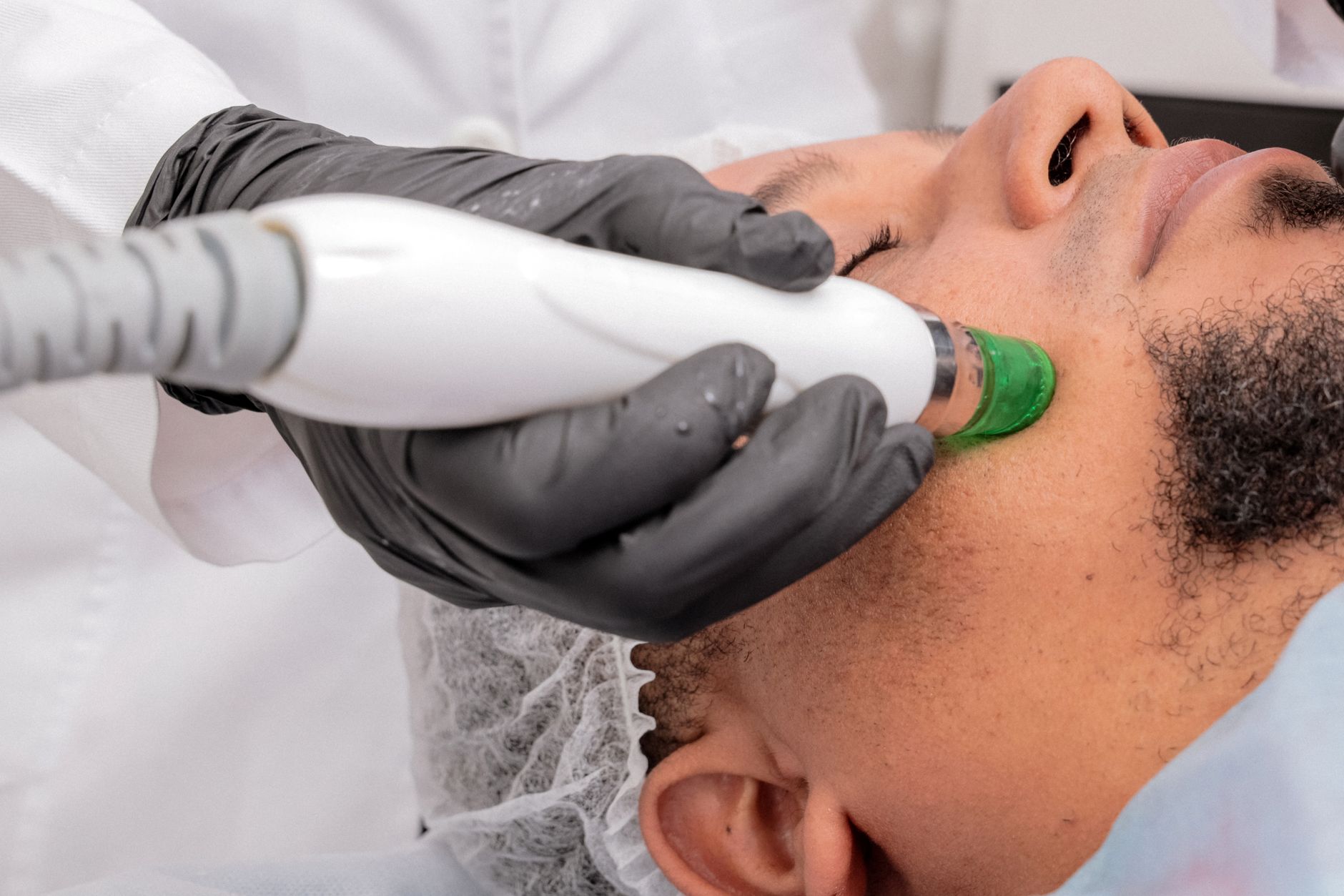 Advanced Aesthetic Procedures: Chemical Peels — A close-up of a man receiving a professional skincare treatment in a clinical setting.