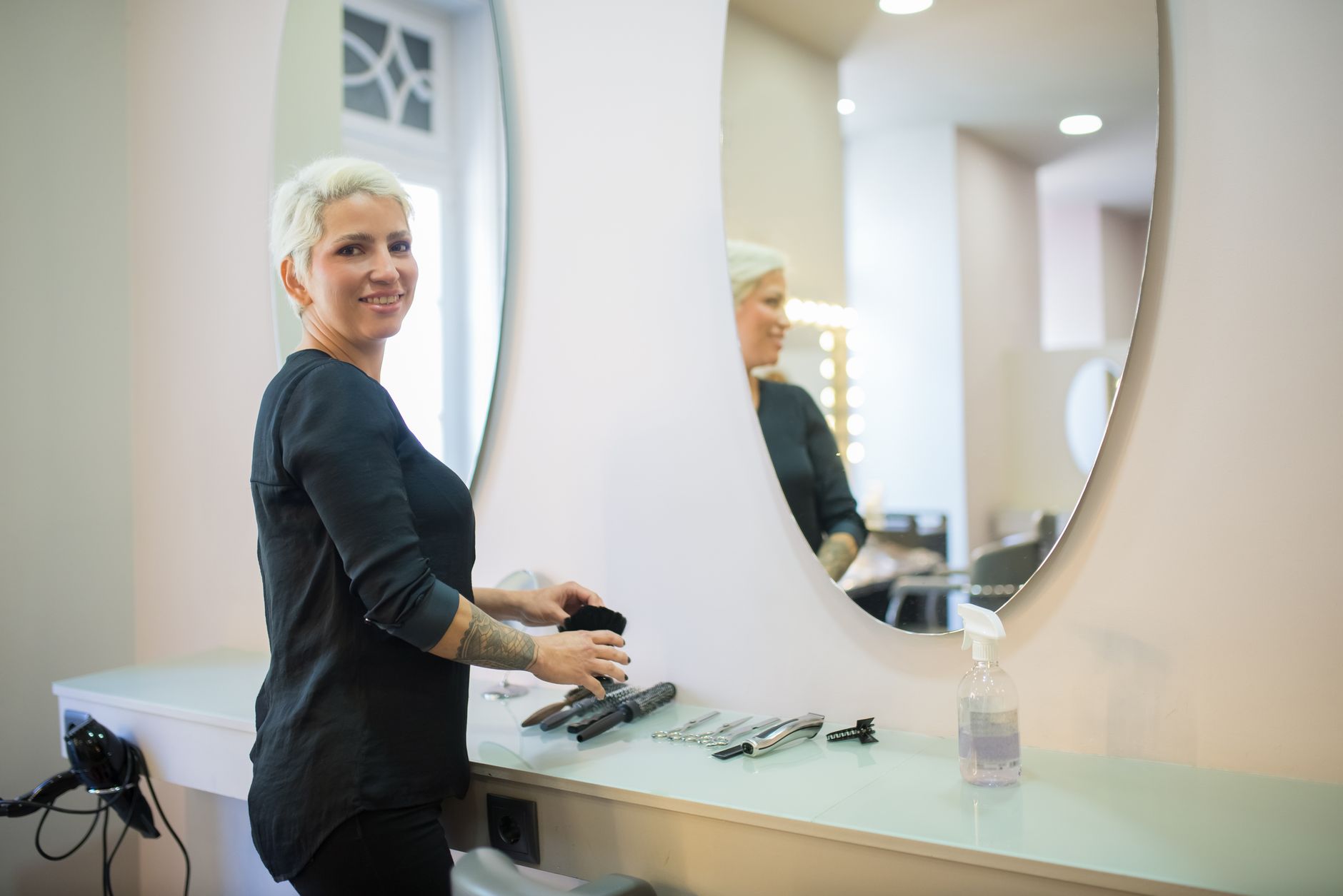 Complication Management for Aesthetic Practice — A hair stylist in a modern salon in portugal with tools and a mirror.
