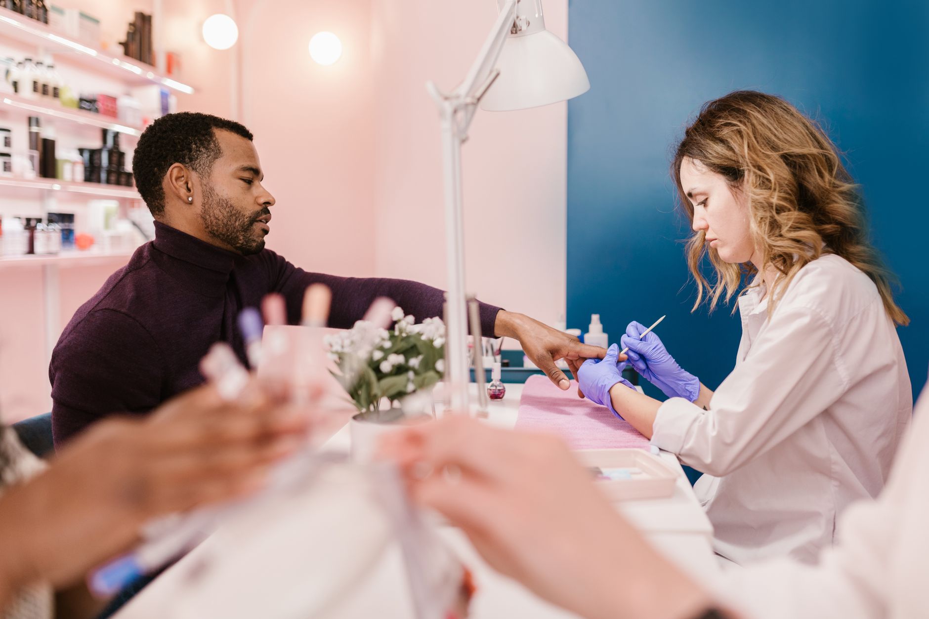 Consultation and Advanced Skin Analysis using Technologies — A man receives a manicure from a nail technician in a stylish, modern salon setting.