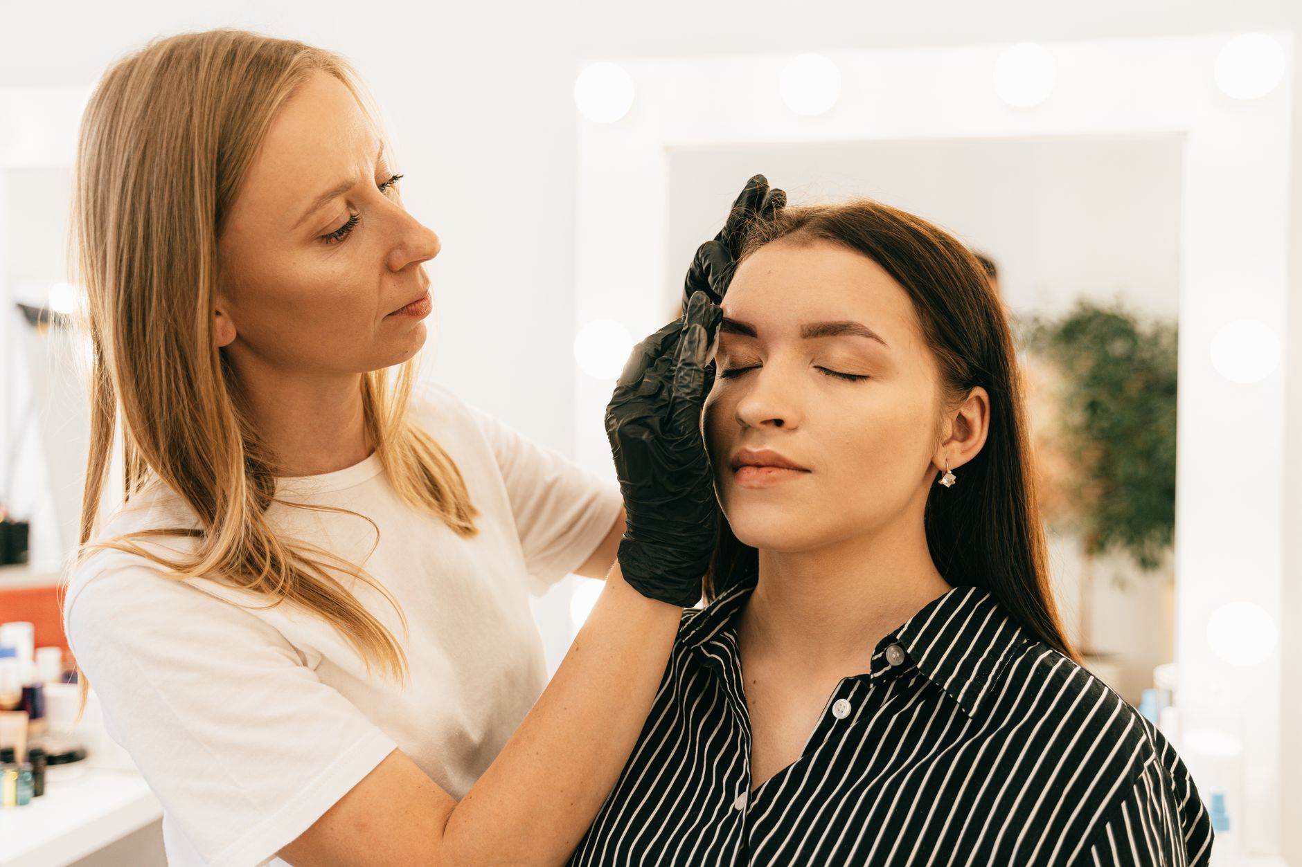 Promotional activities — Makeup artist applying foundation in a well-lit studio setting, focusing on beauty and preparation.