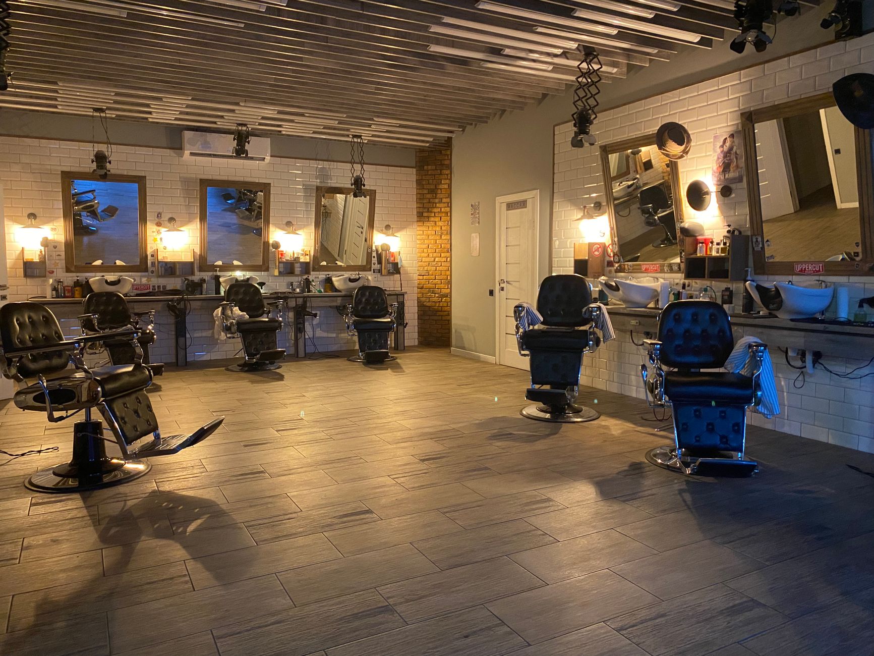 Hair Science for barbering — Spacious and stylish hair salon featuring empty barber chairs, mirrors, and elegant lighting.