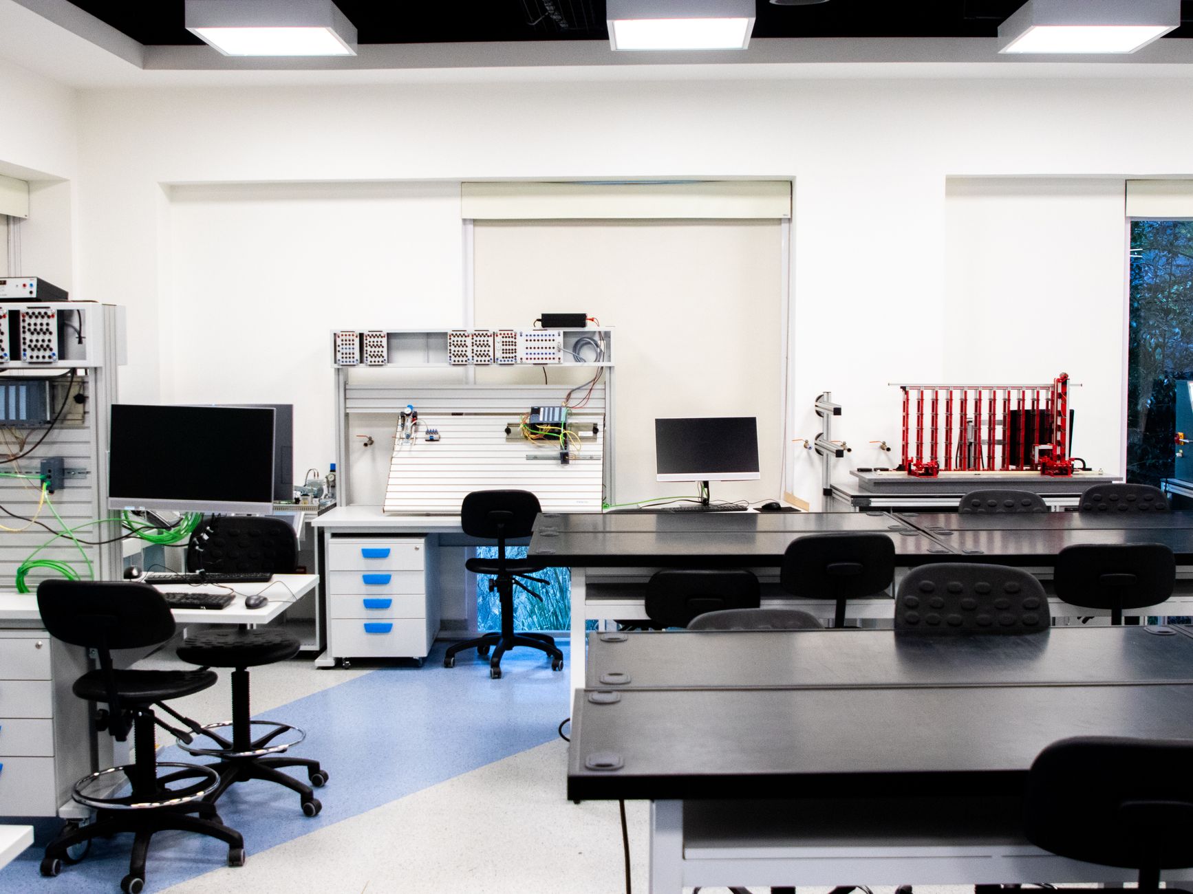 units and at least 3 — Bright and well-equipped modern technology lab featuring computers, workstations, and desks.